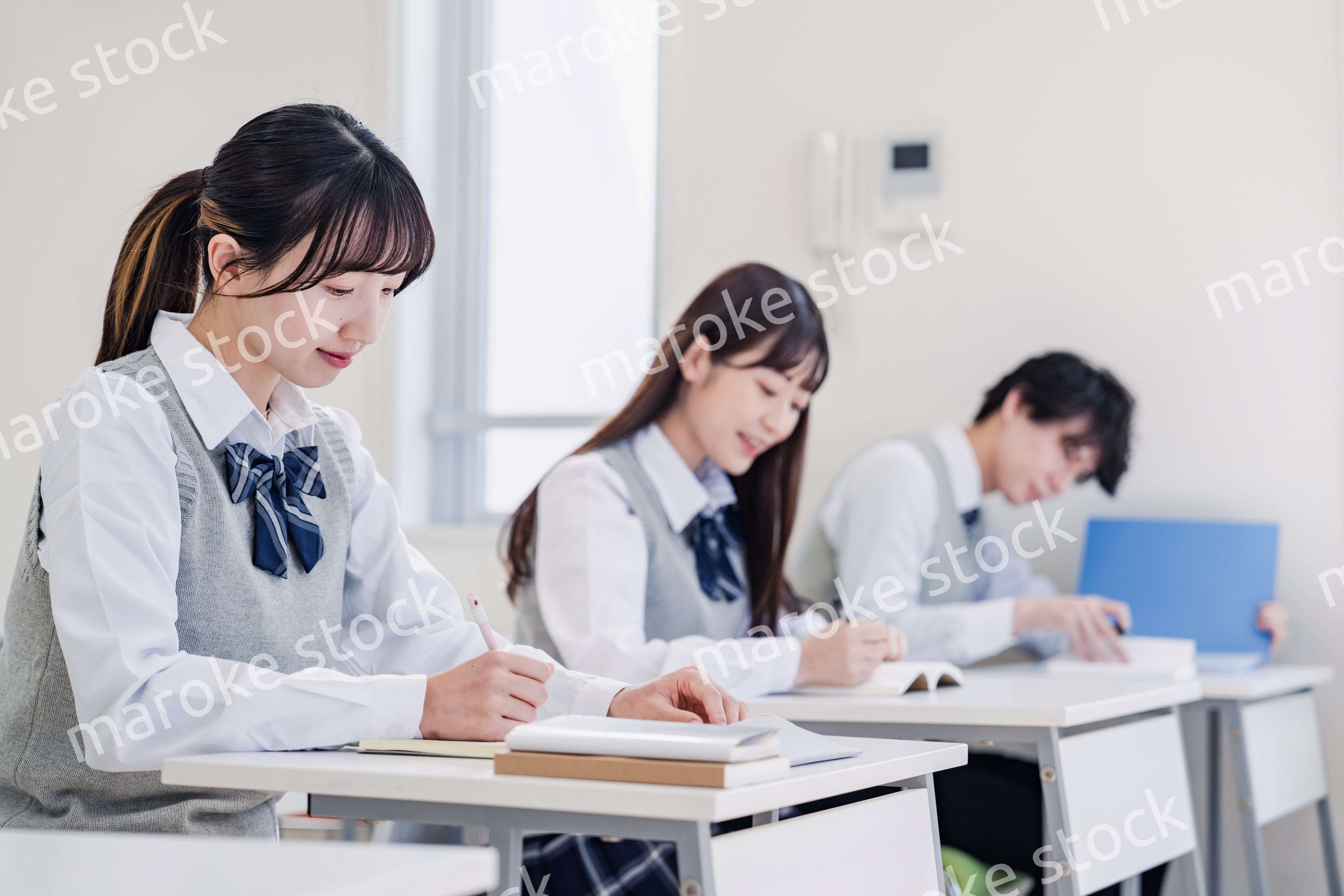 集中してノートを取る高校生