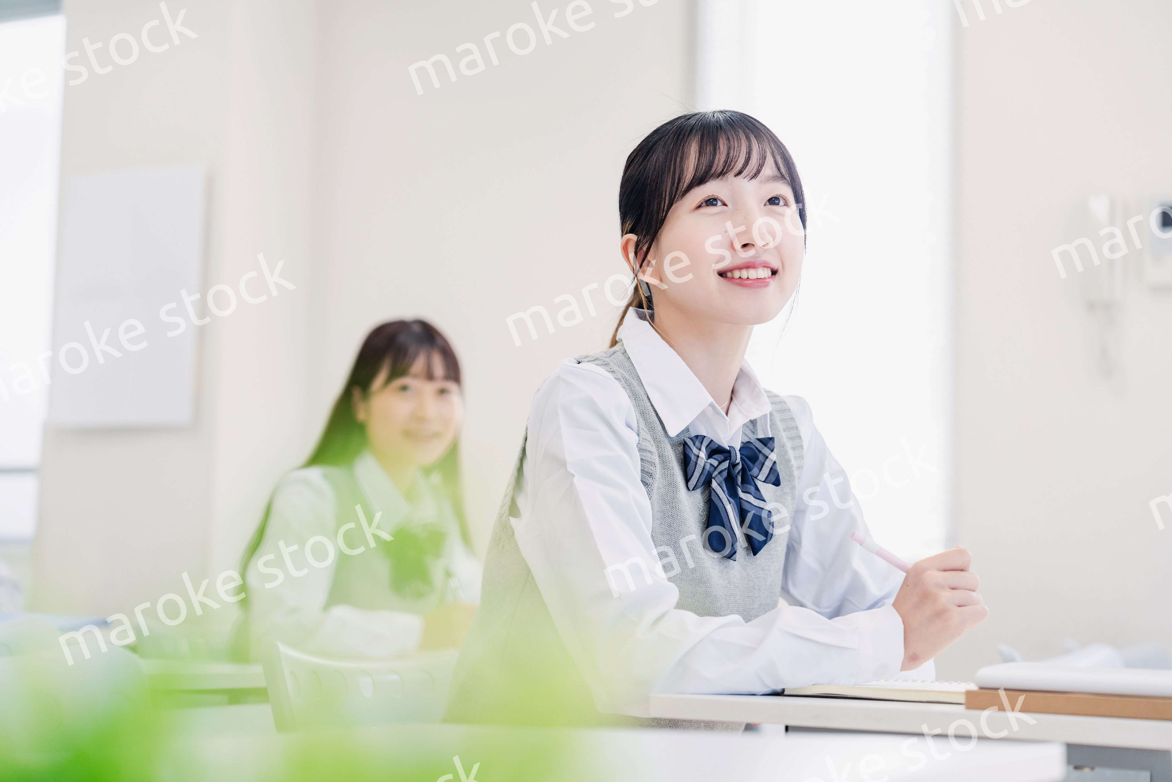 教室でにこやかに授業を受ける女子高生