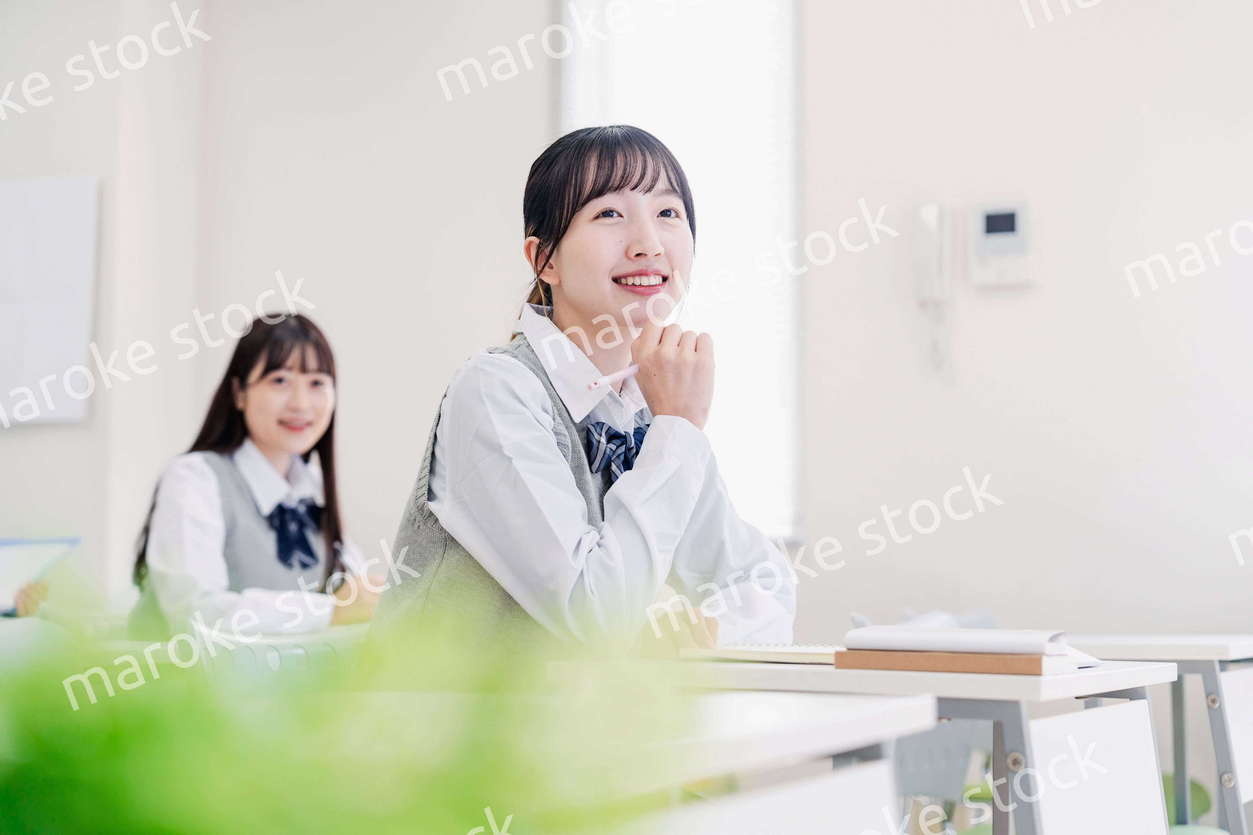 教室でにこやかに授業を受ける女子高生