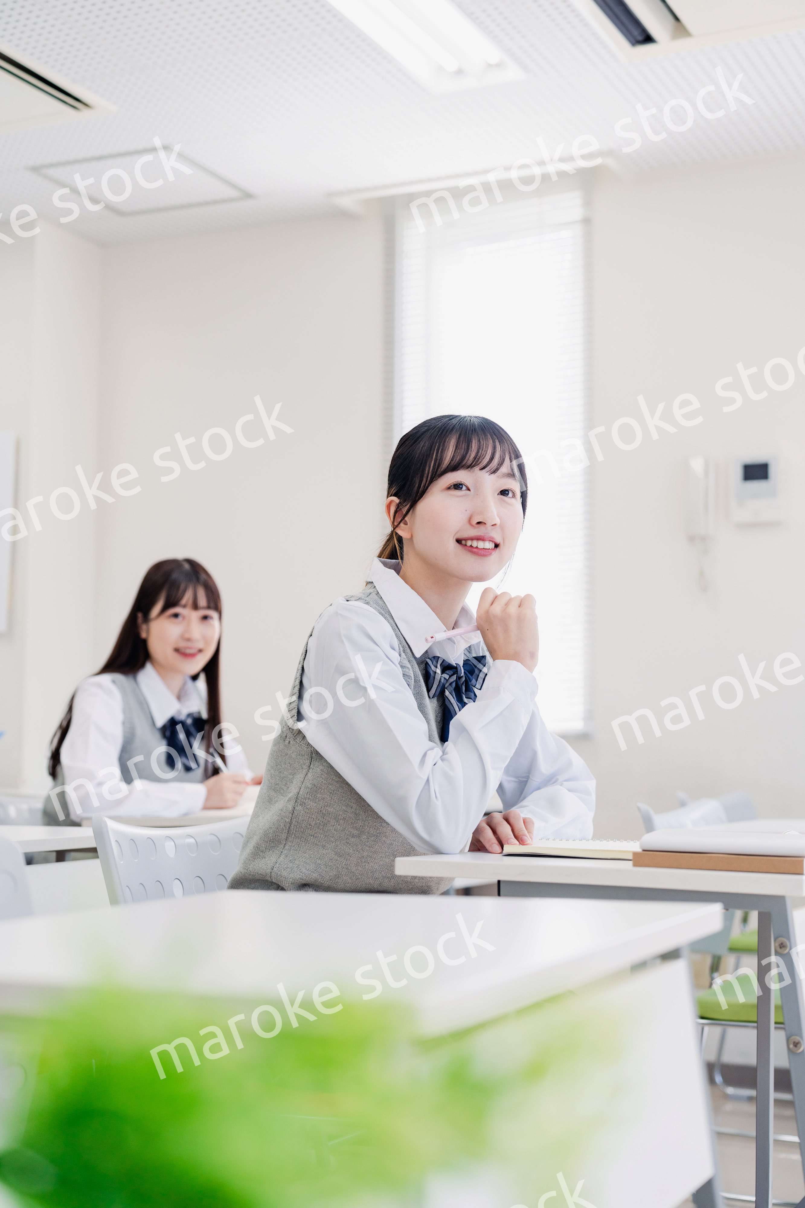 教室でにこやかに授業を受ける女子高生