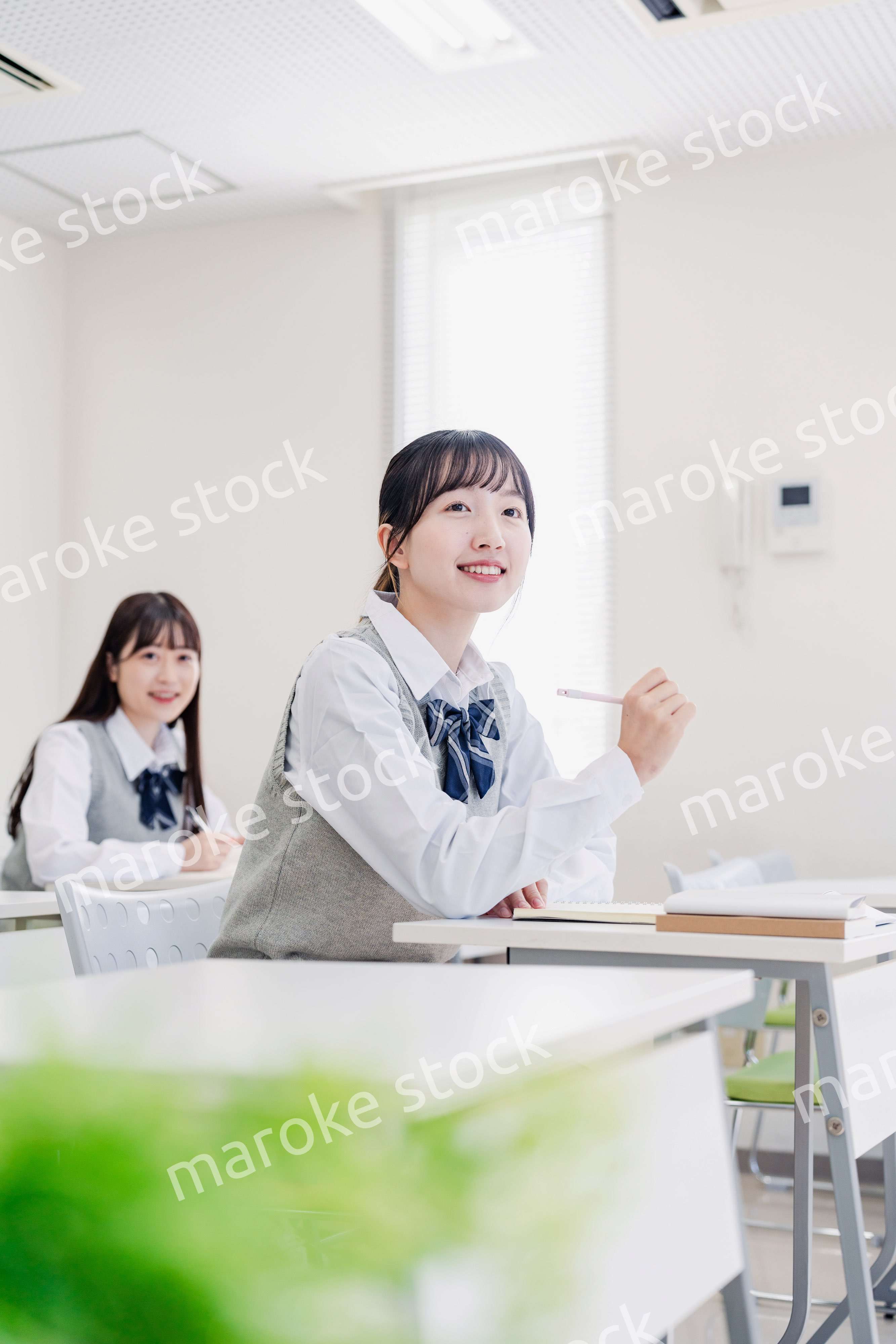 手を上げて発表をする女子高生