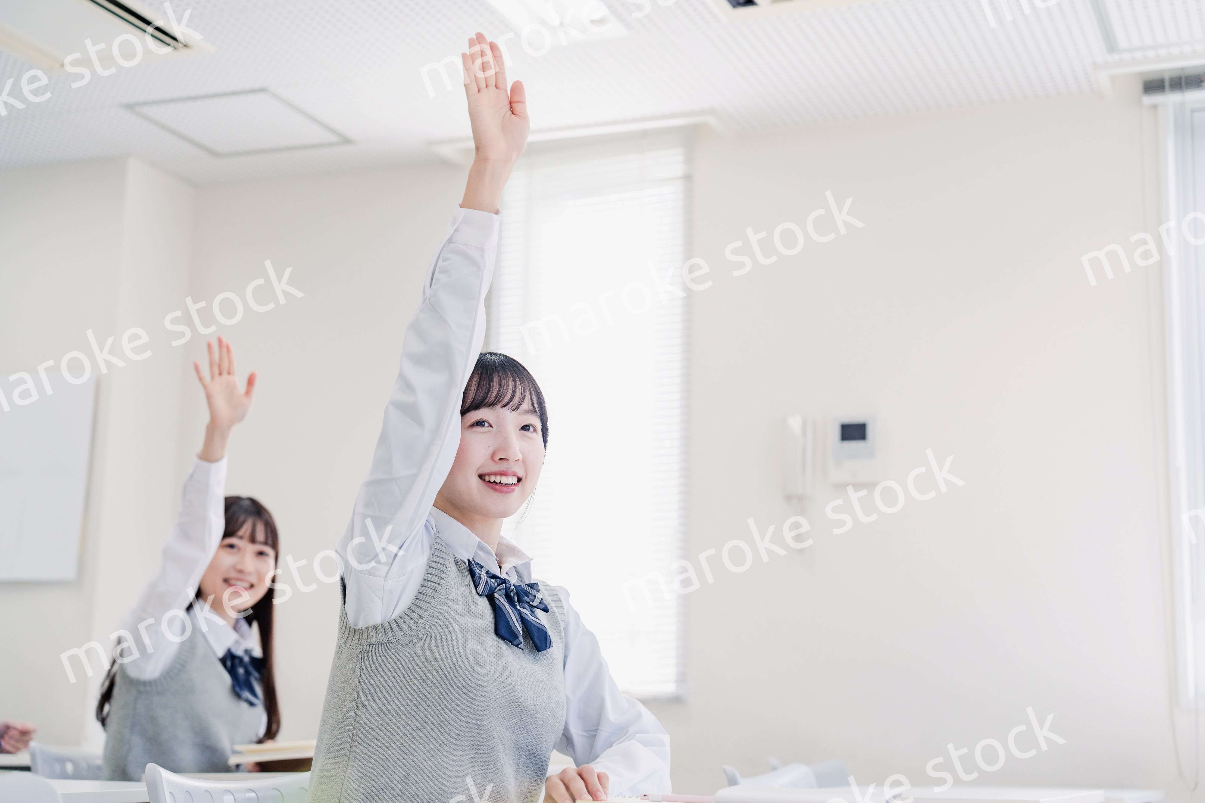 手を上げて発表をする女子高生