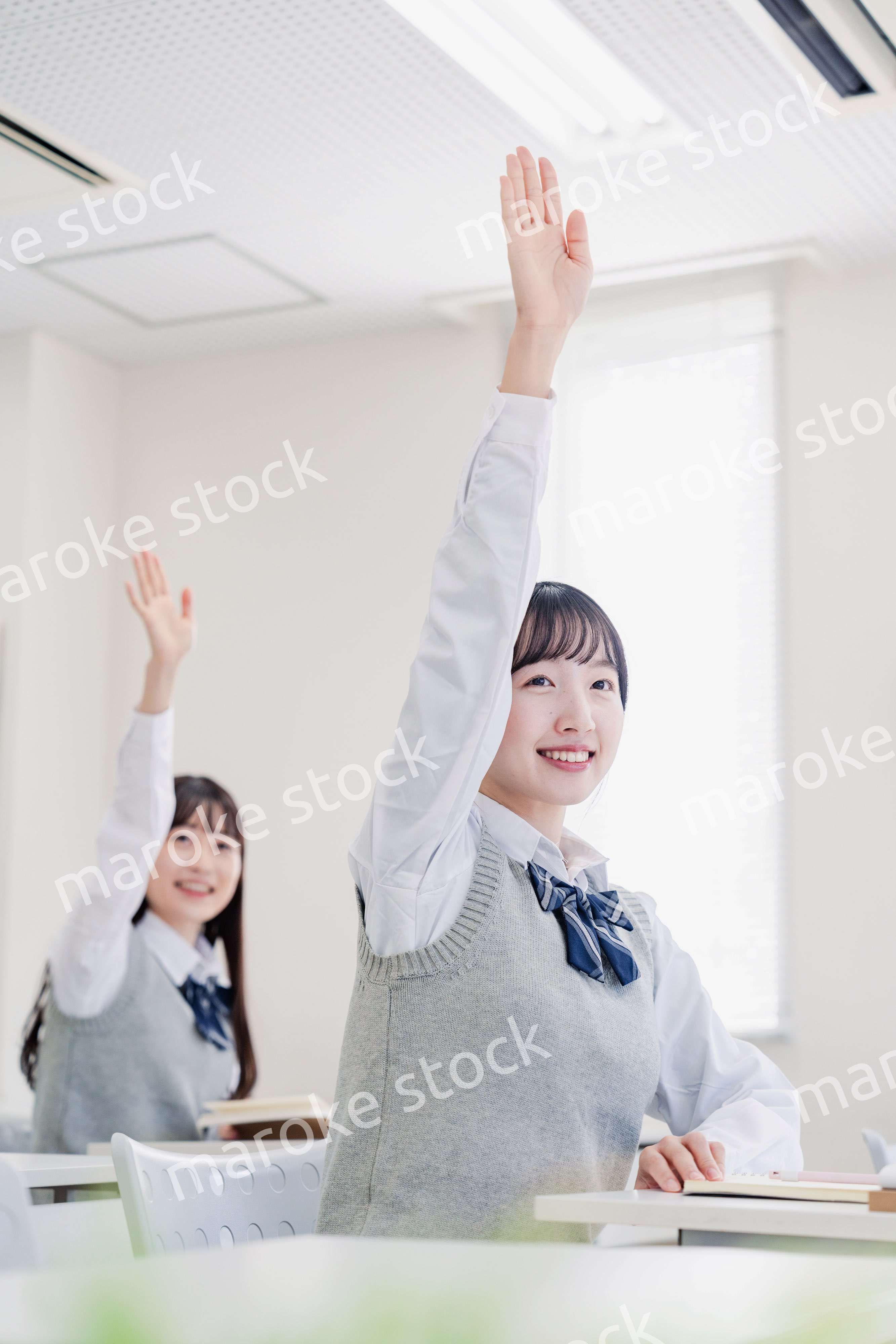 手を上げて発表をする女子高生