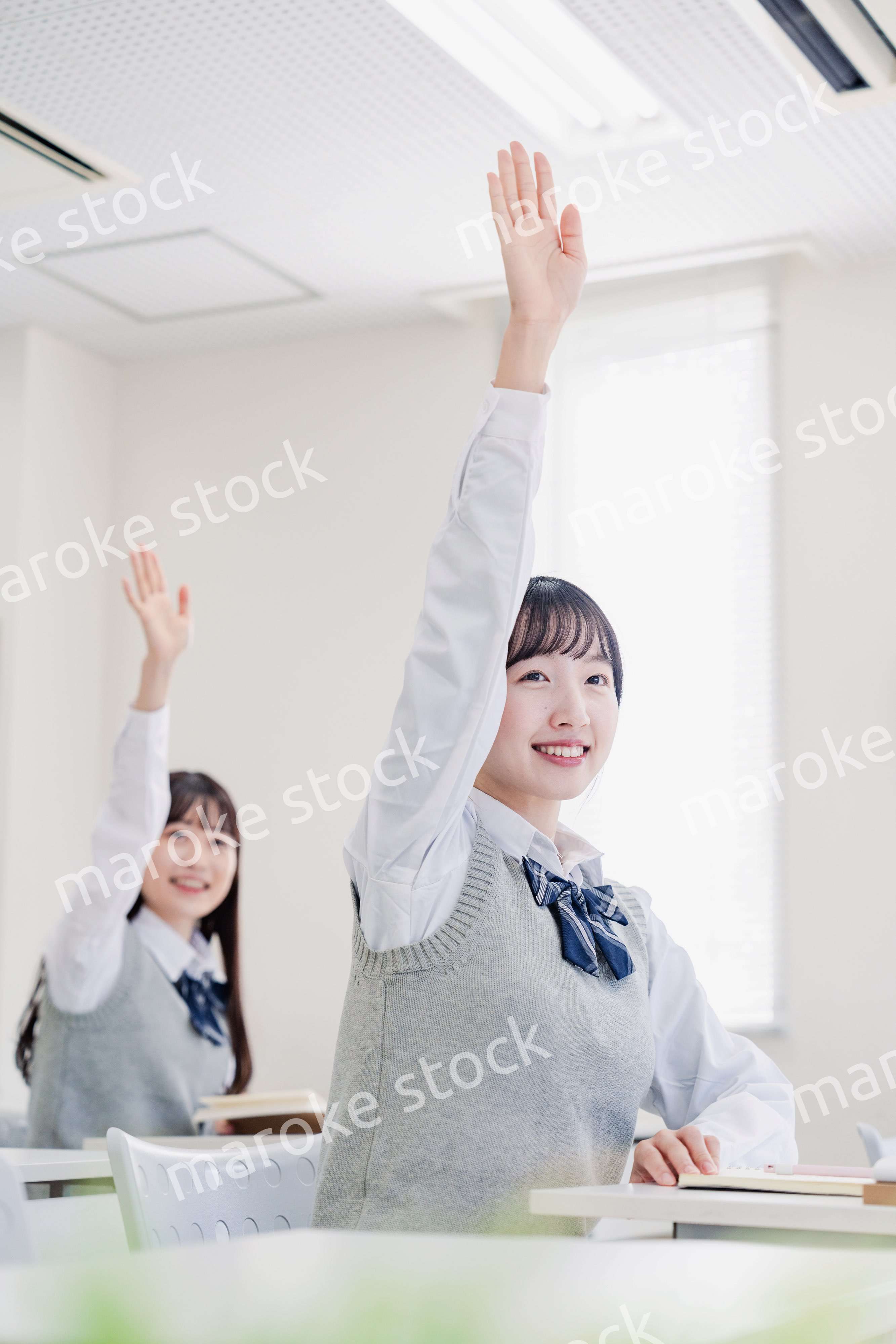 手を上げて発表をする女子高生