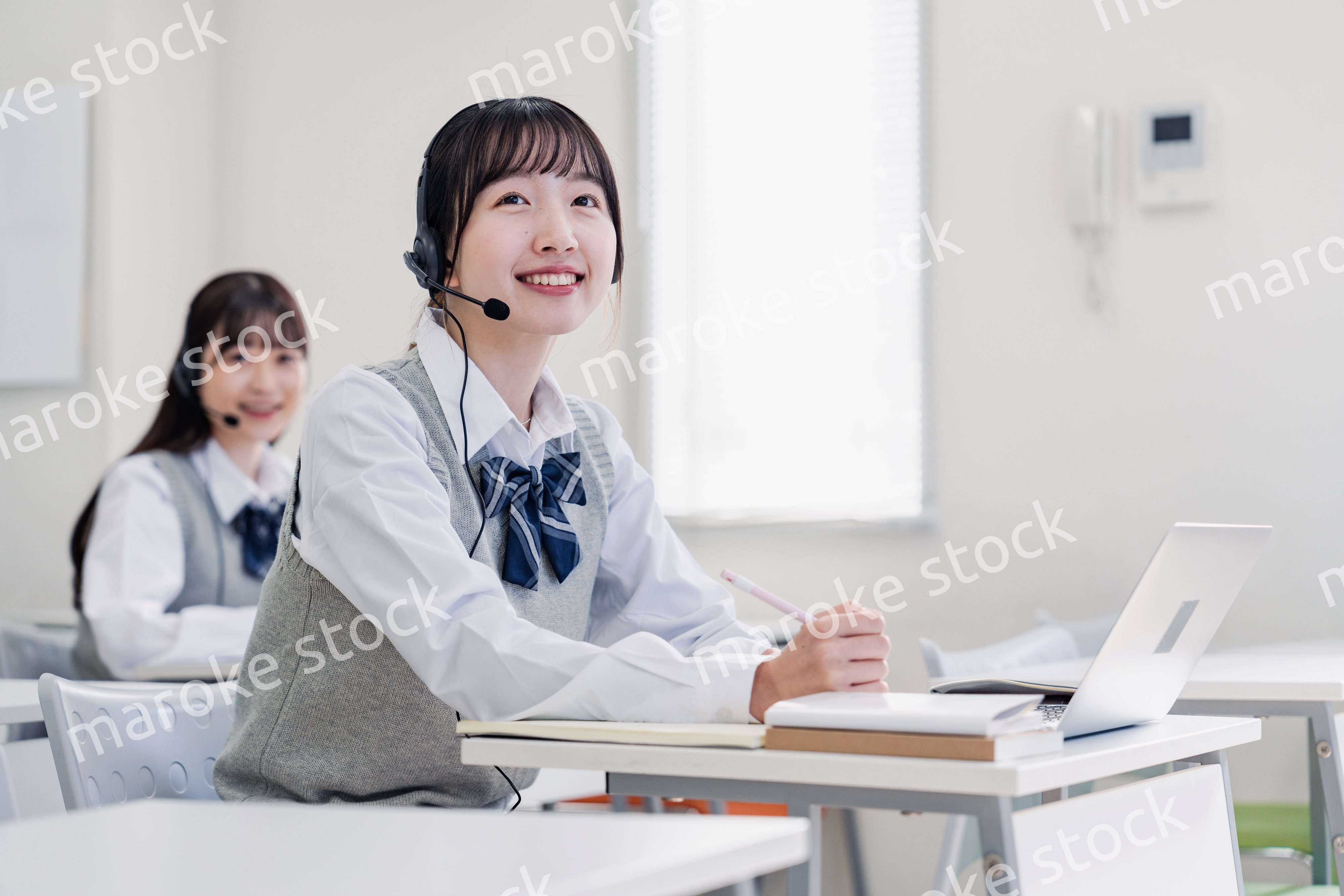 教室でノートパソコンを使う女子高生