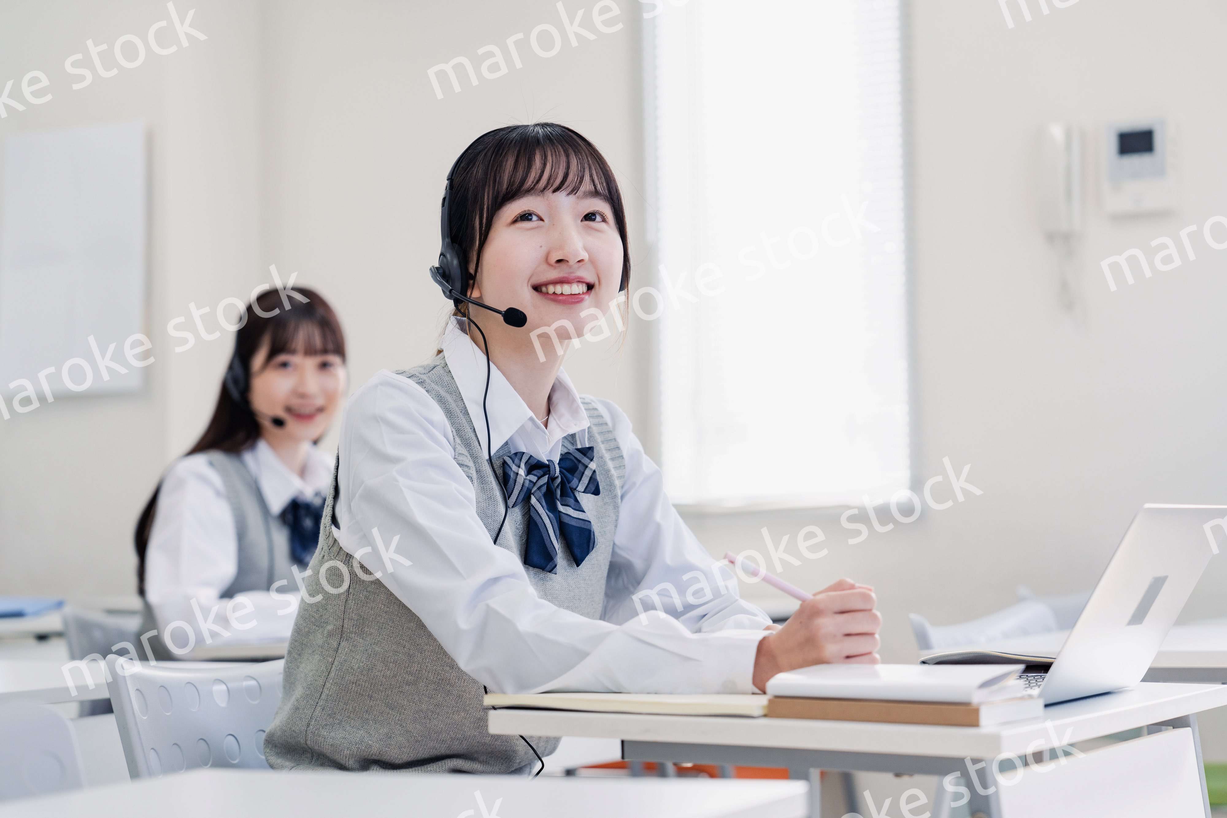 教室でノートパソコンを使う女子高生