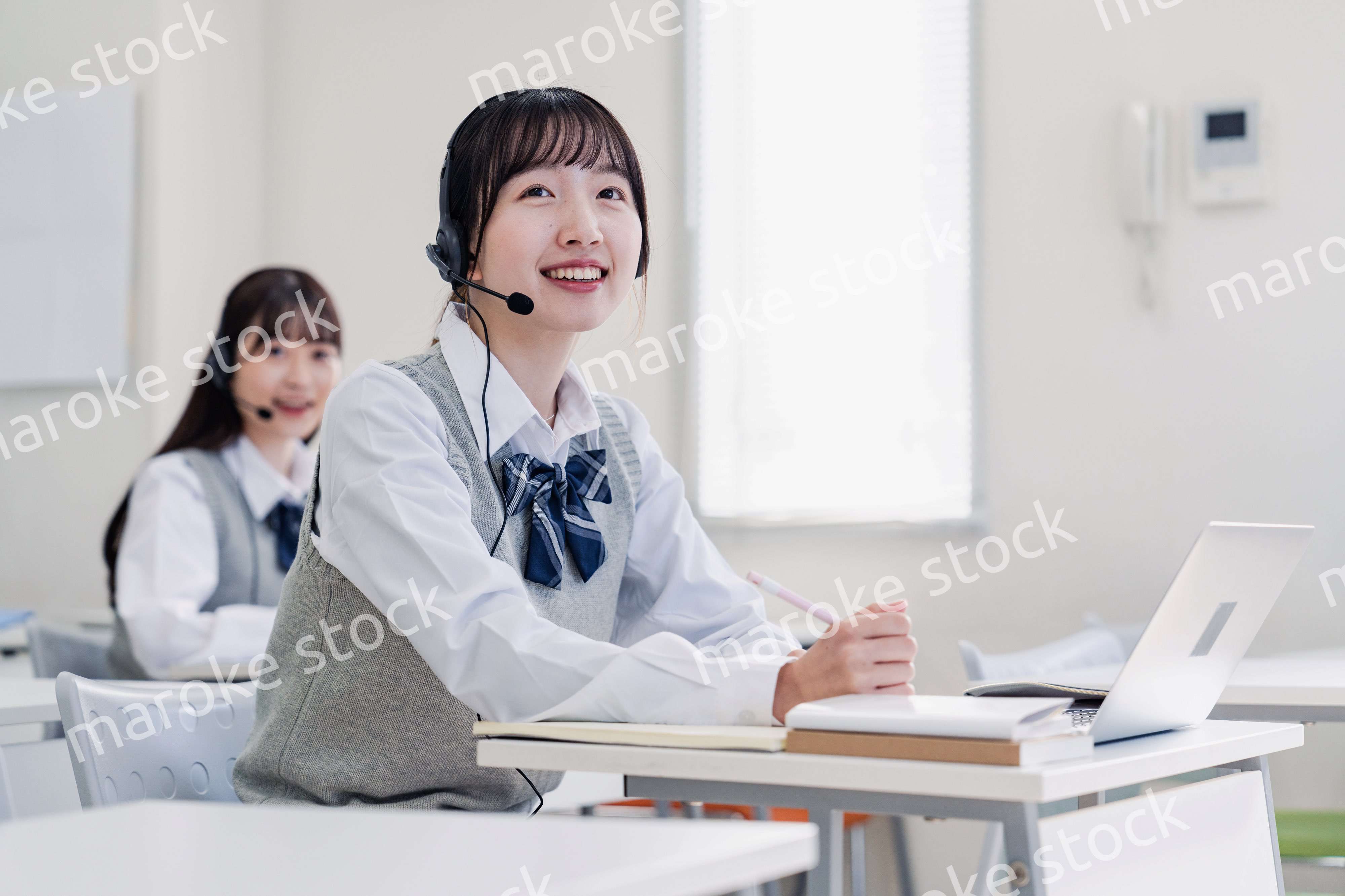 教室でノートパソコンを使う女子高生