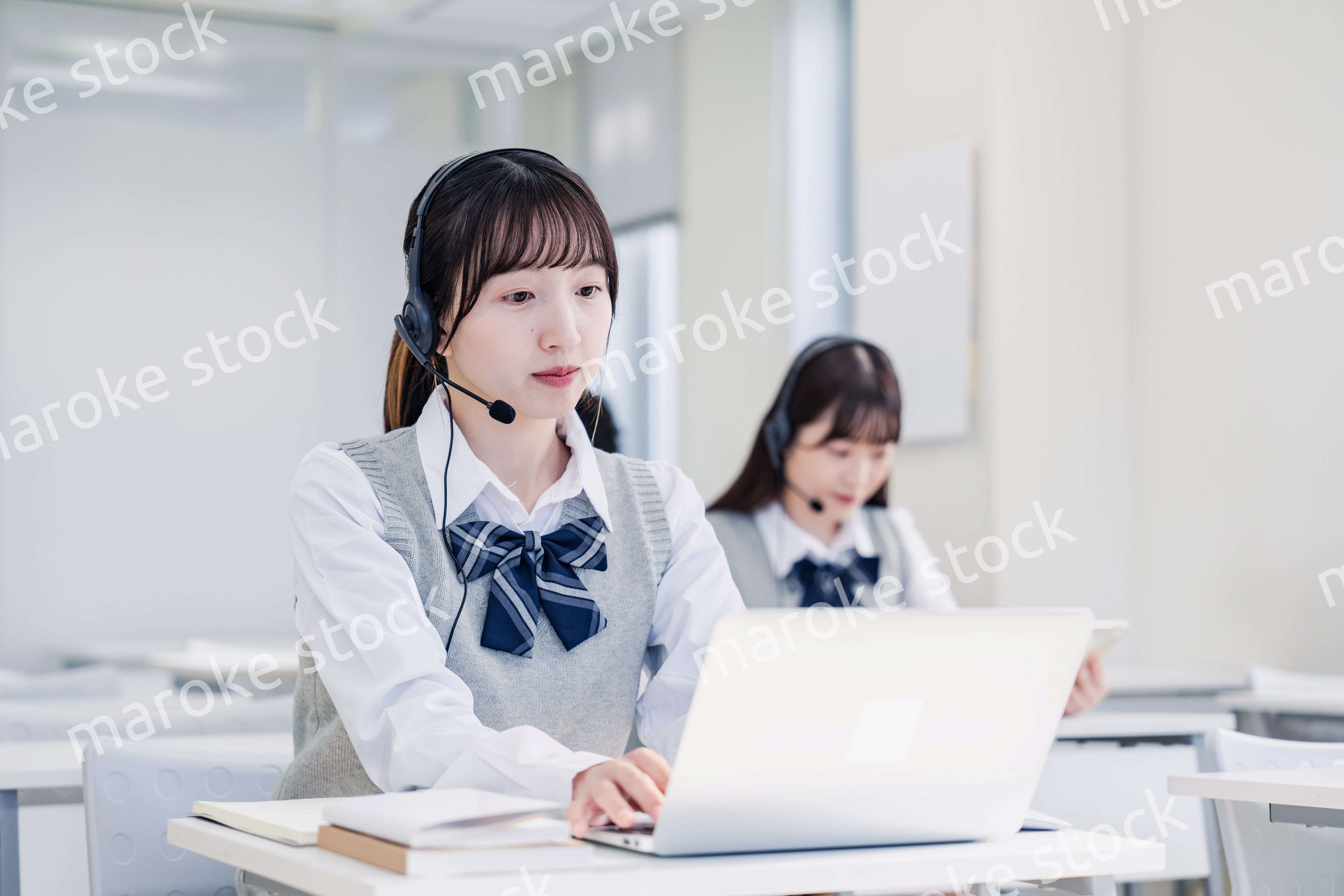 教室でノートパソコンを使う女子高生