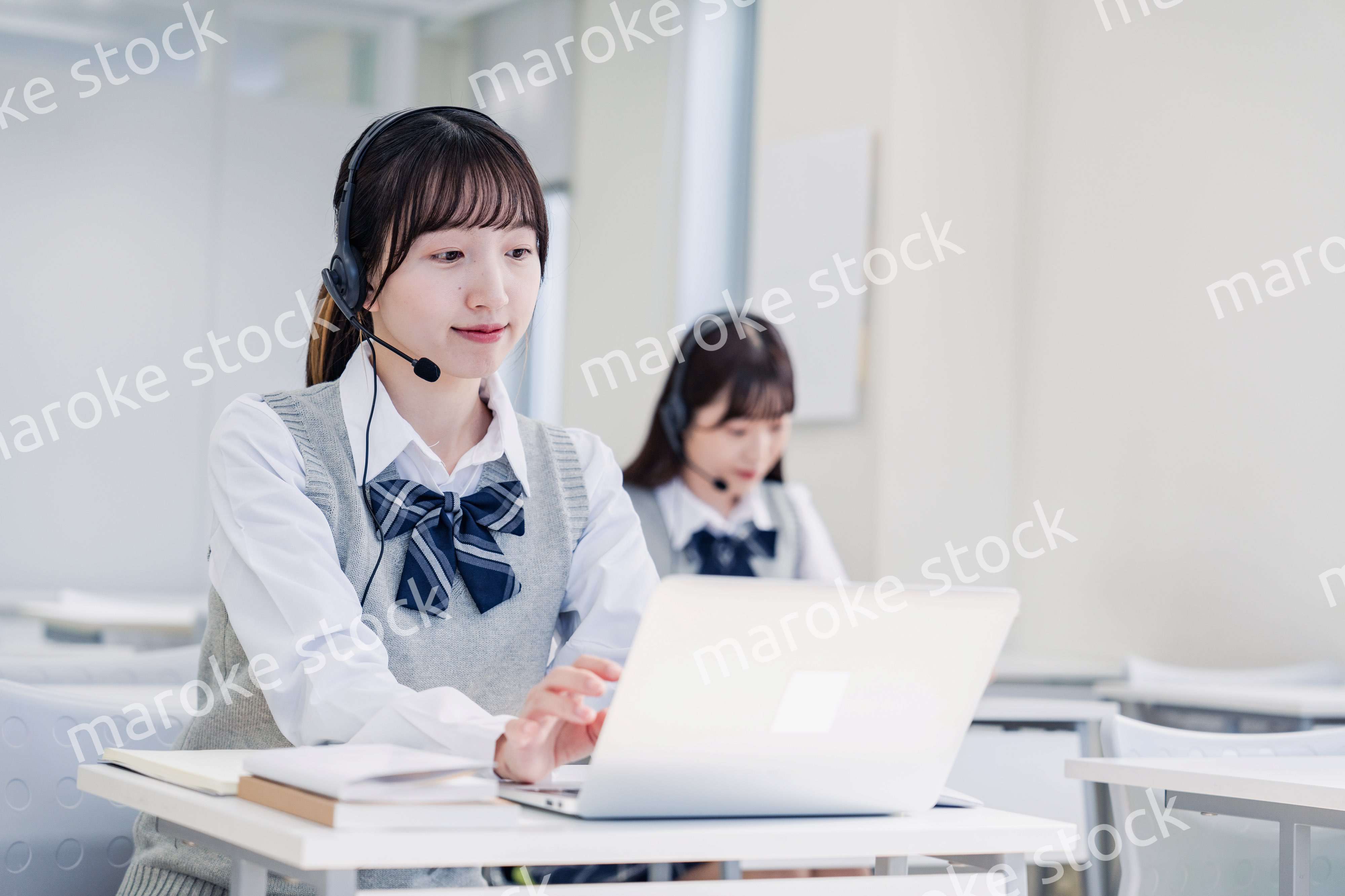 教室でノートパソコンを使う女子高生