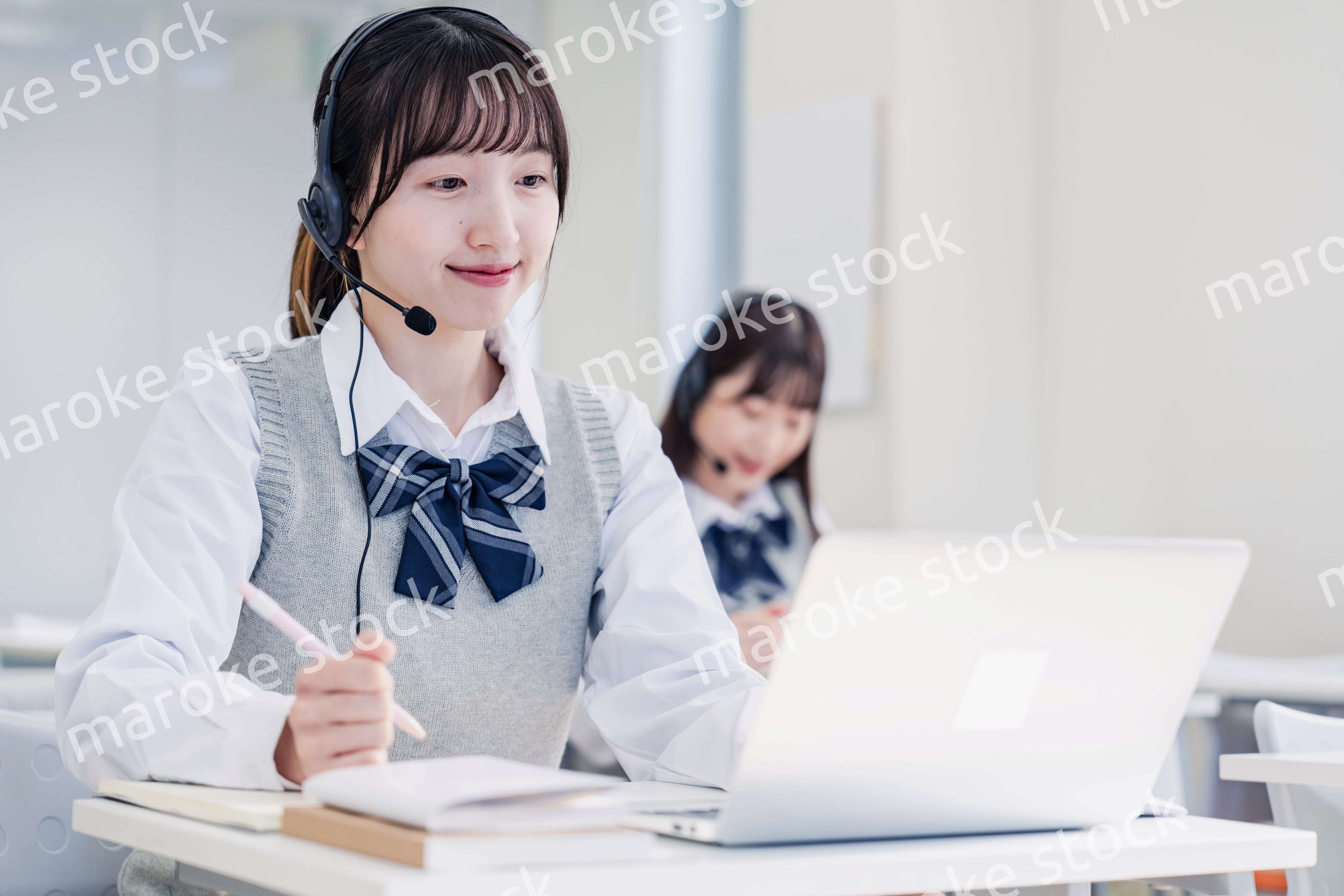 教室でノートパソコンを使う女子高生