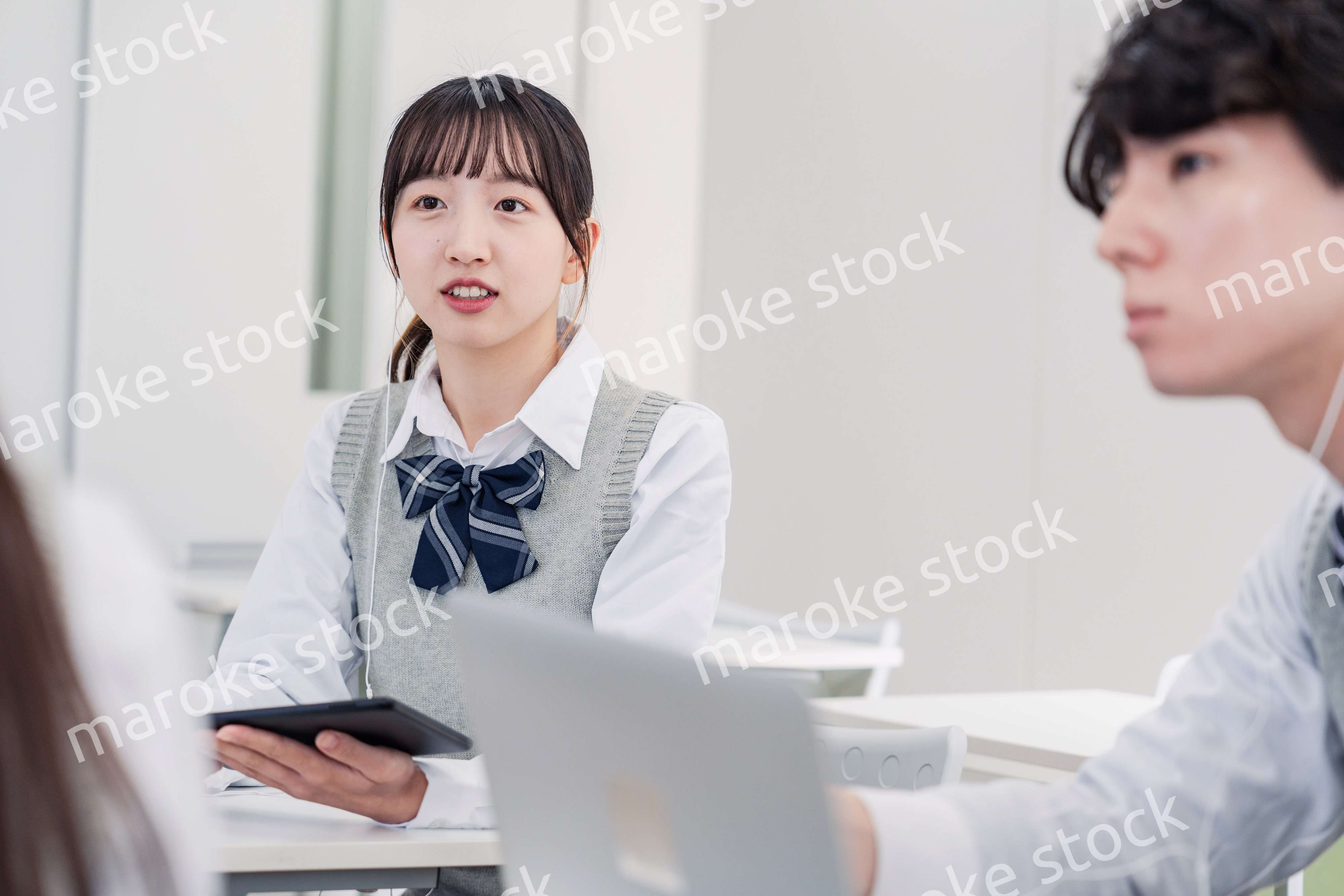 タブレットを使いながら討論をする高校生