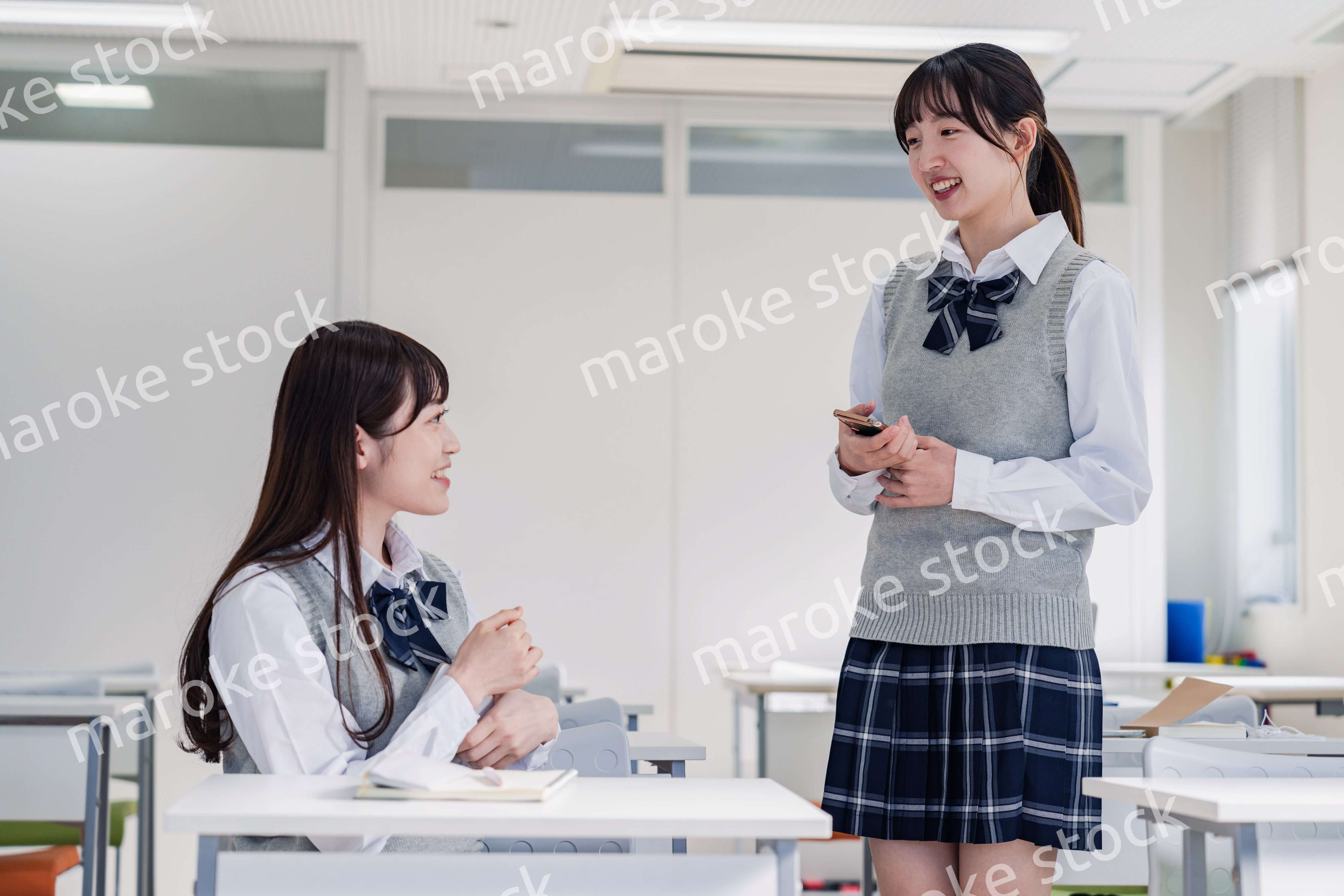 教室で休み時間に話す女子高生