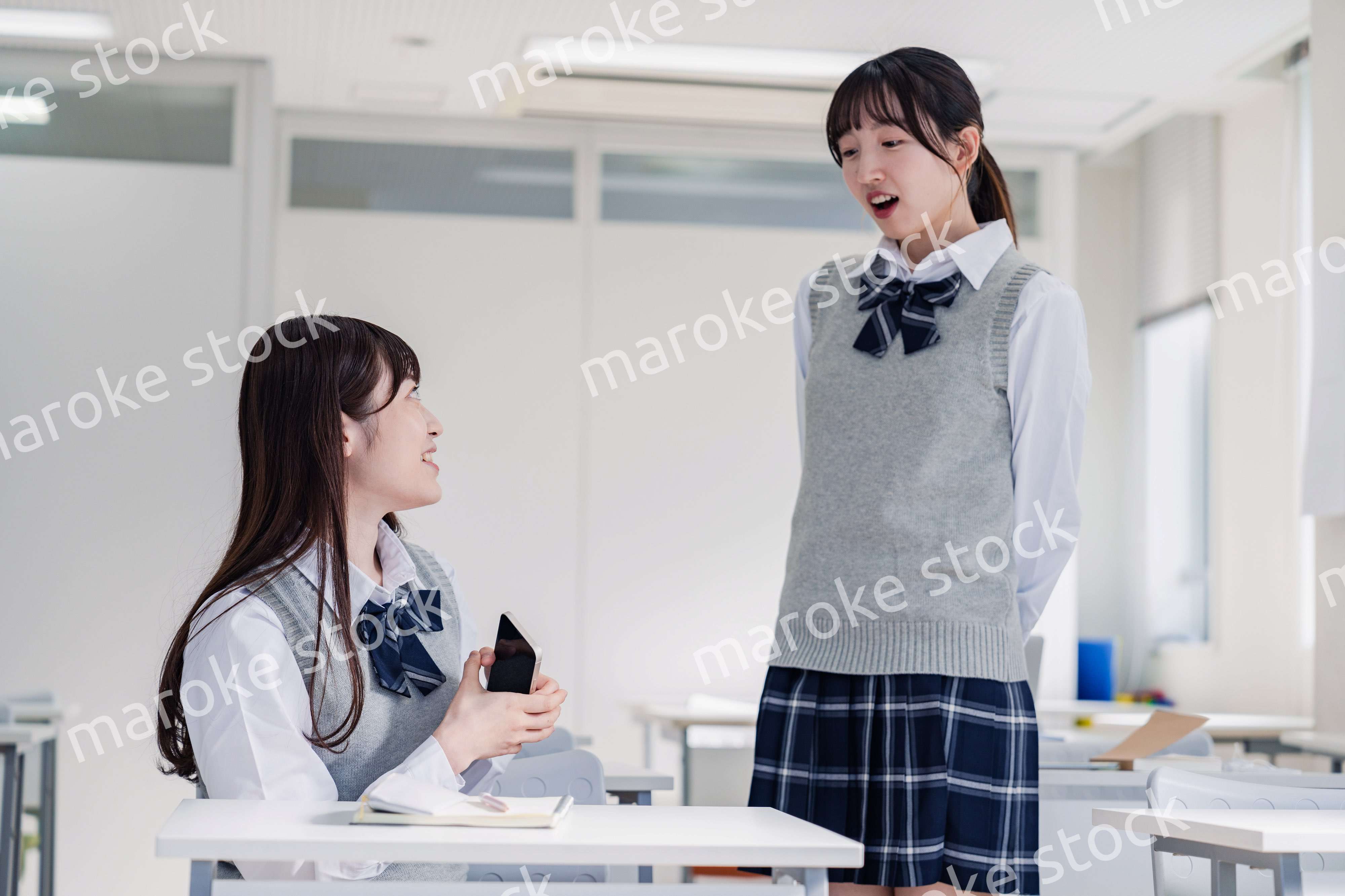 教室で休み時間に話す女子高生