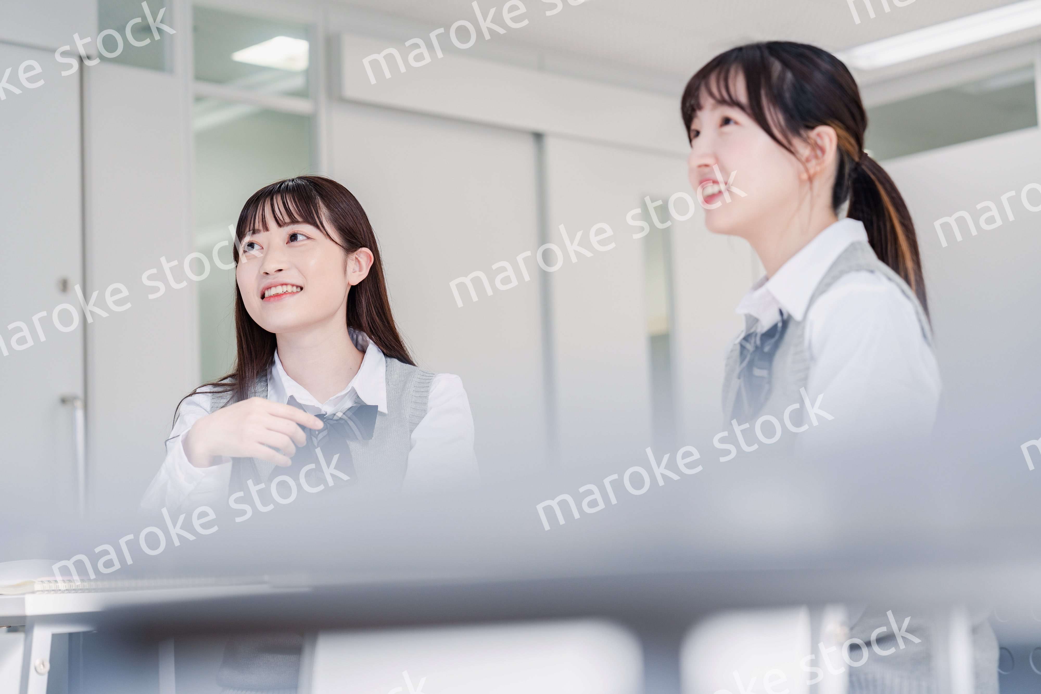 教室で休み時間に話す女子高生