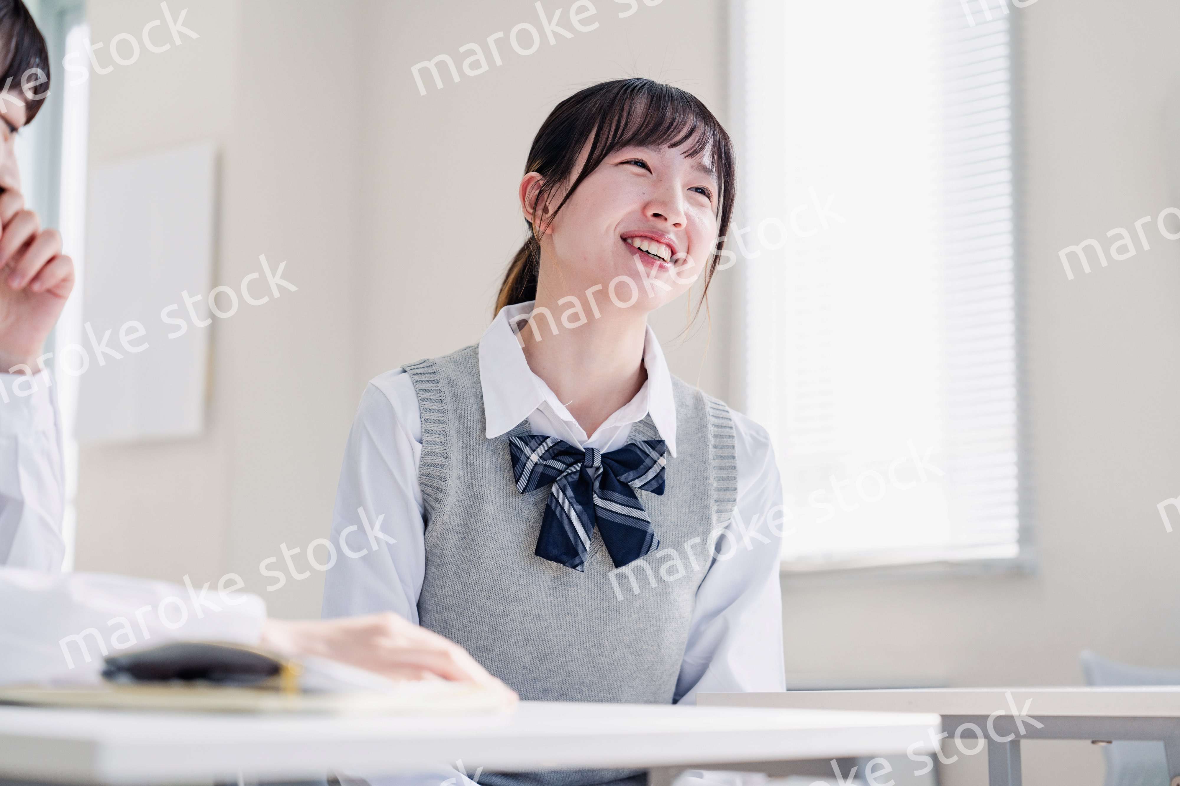 教室で休み時間に話す女子高生