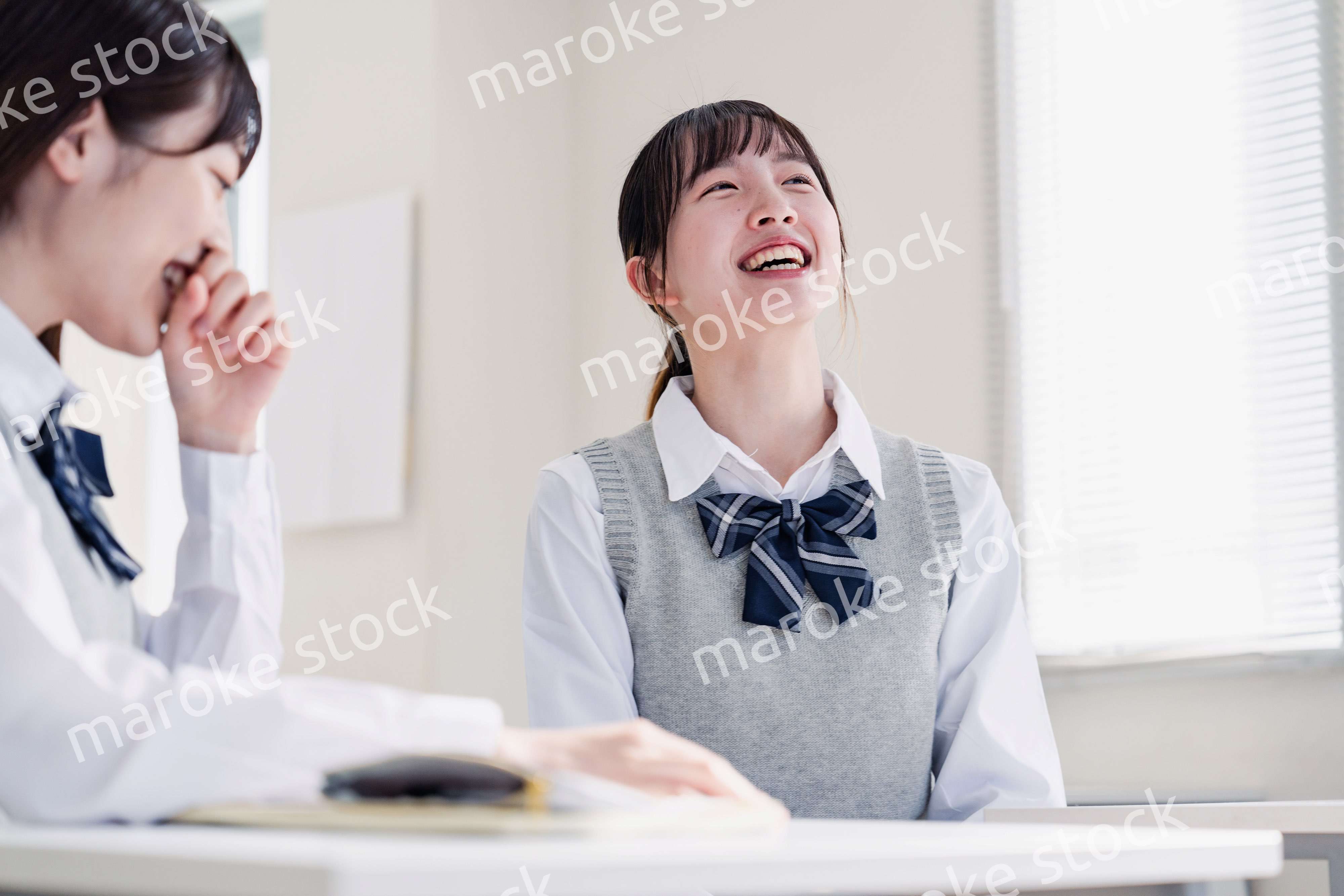 教室で休み時間に話す女子高生