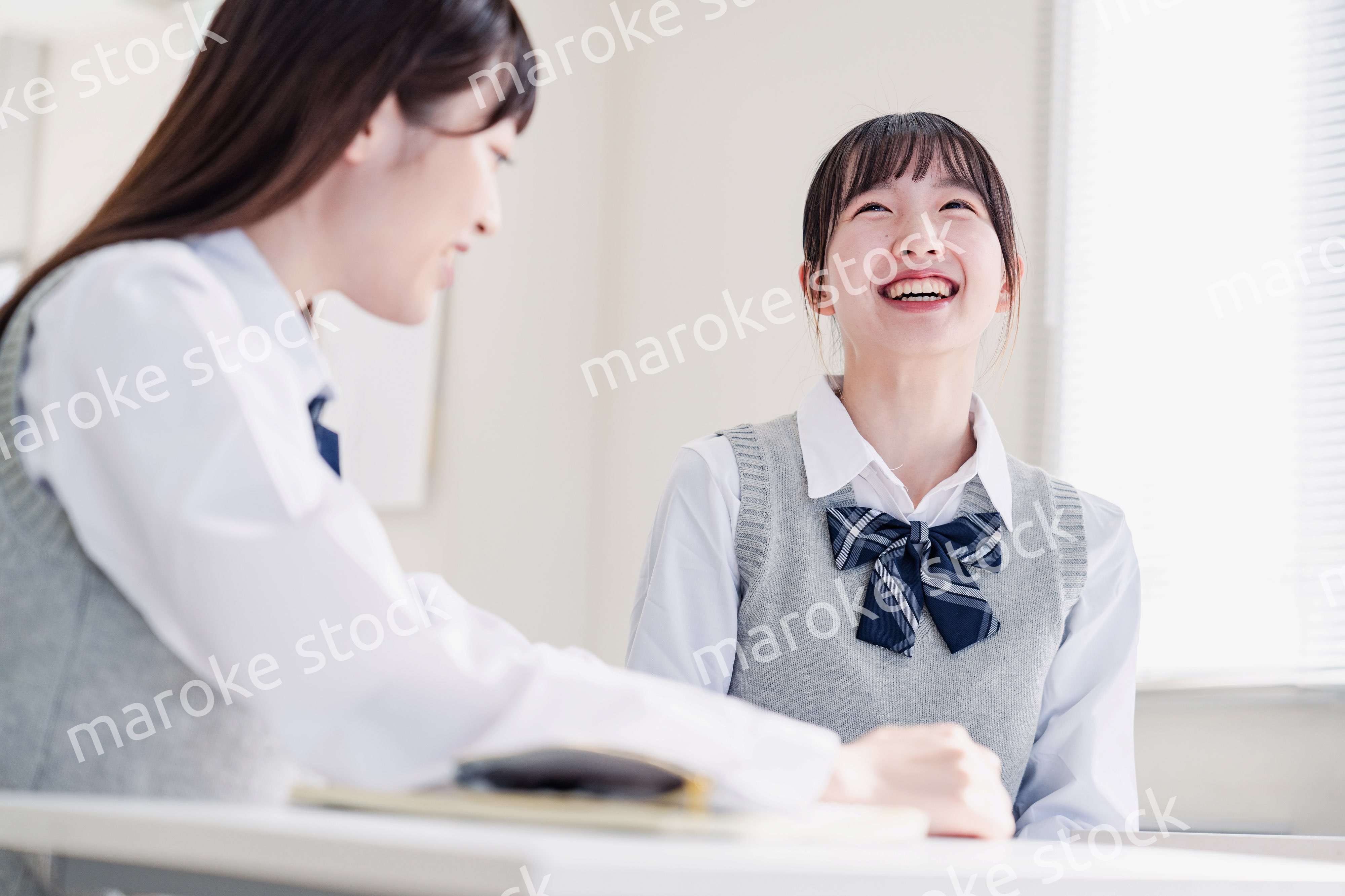 教室で休み時間に話す女子高生