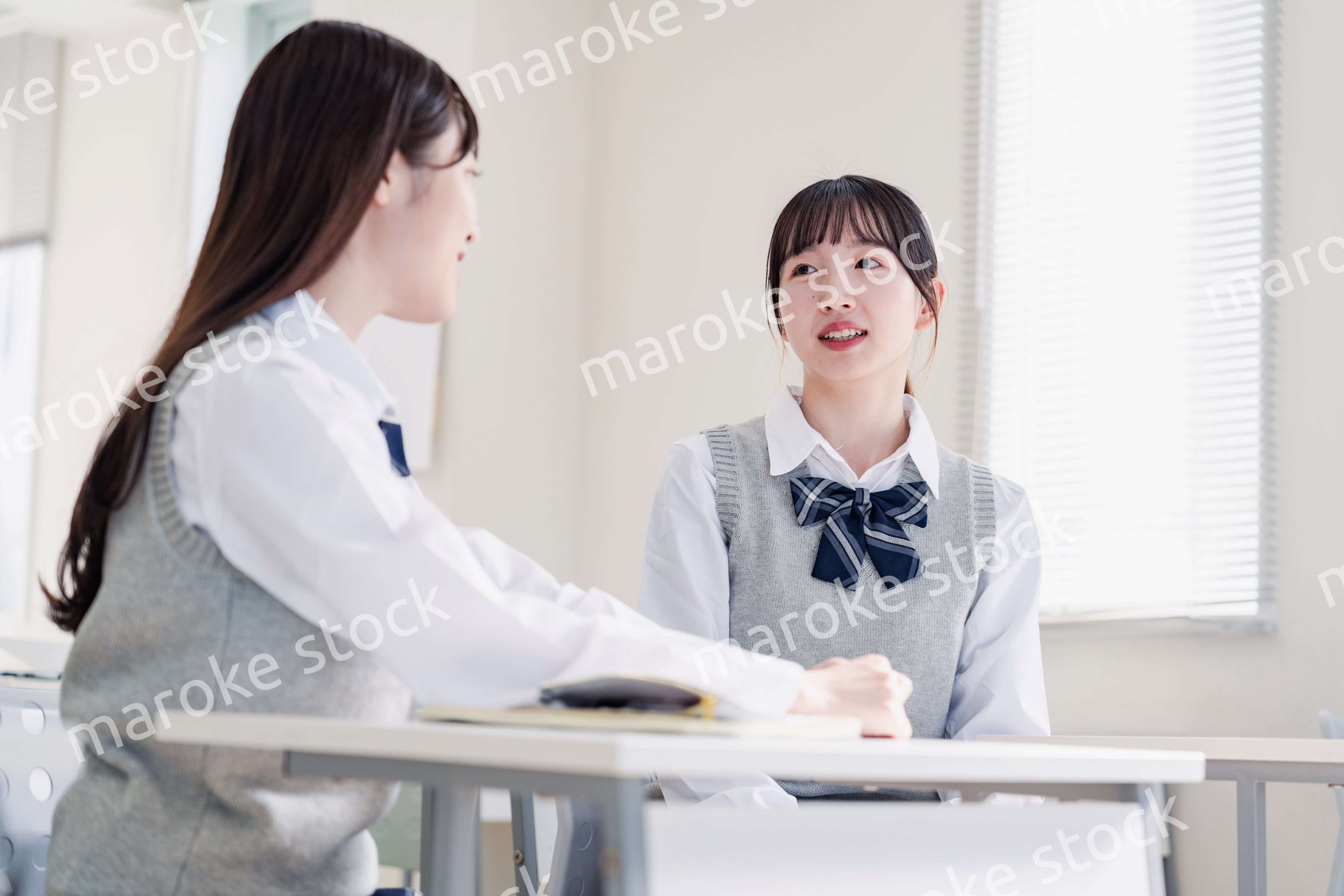 教室で休み時間に話す女子高生