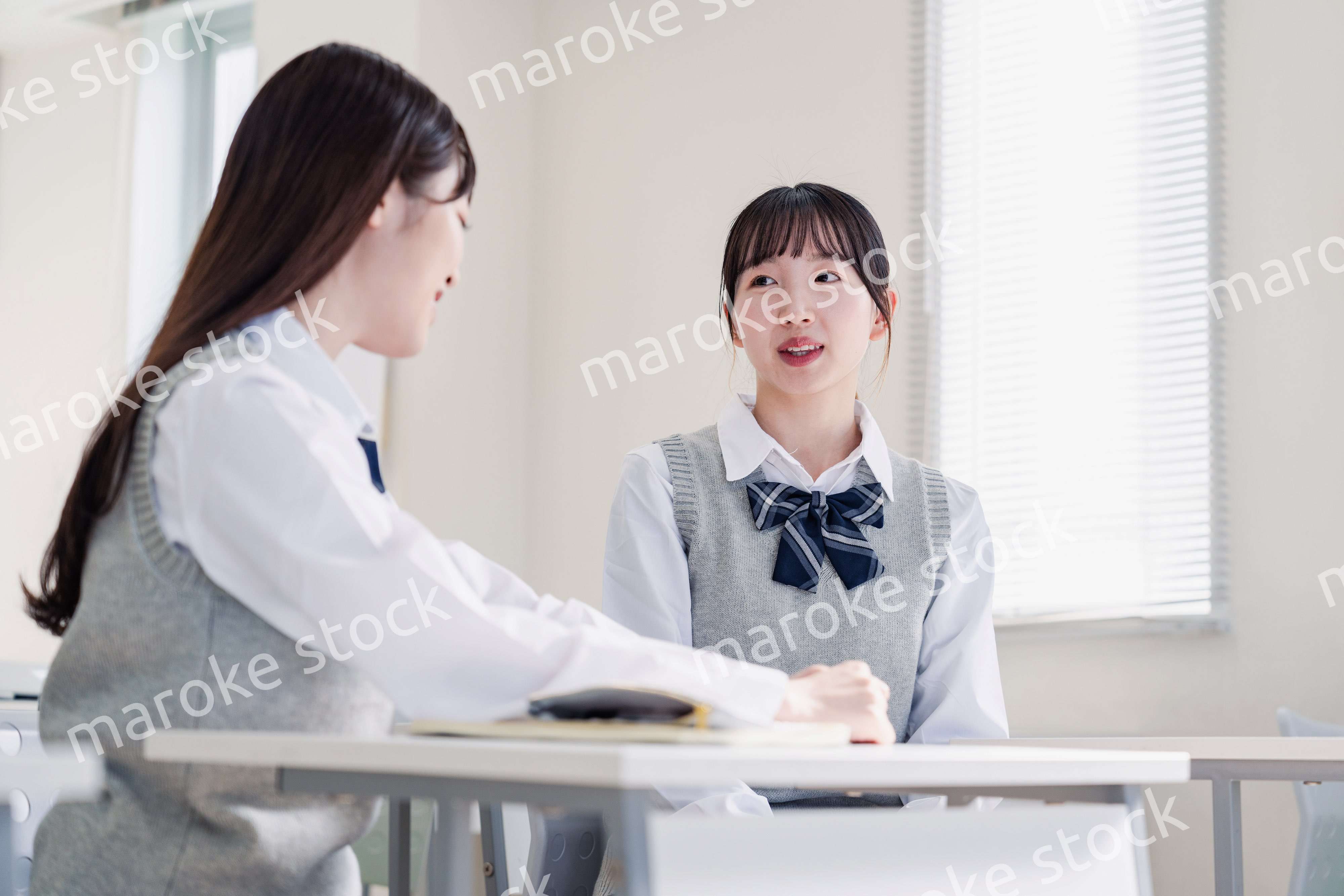 教室で休み時間に話す女子高生