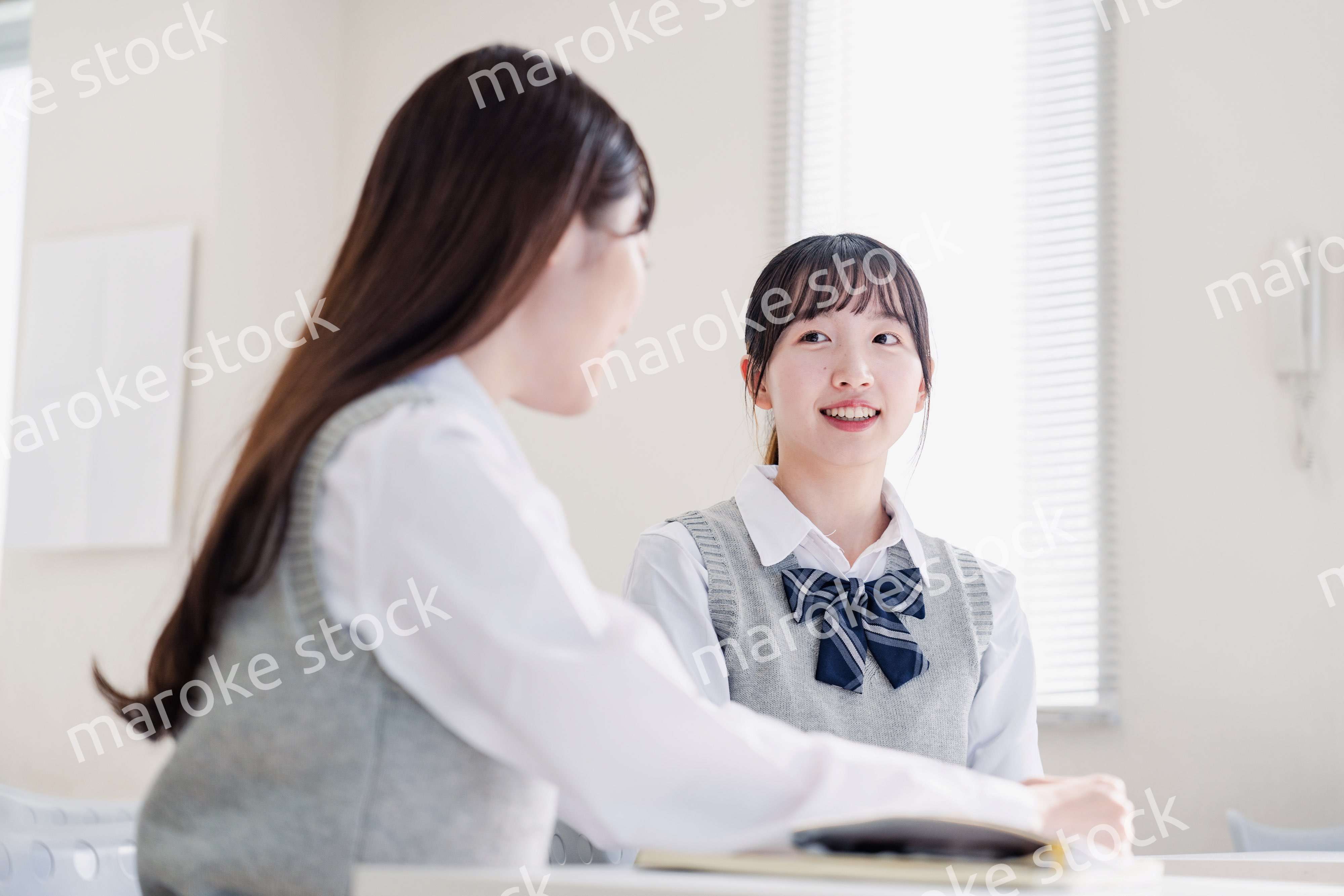 教室で休み時間に話す女子高生