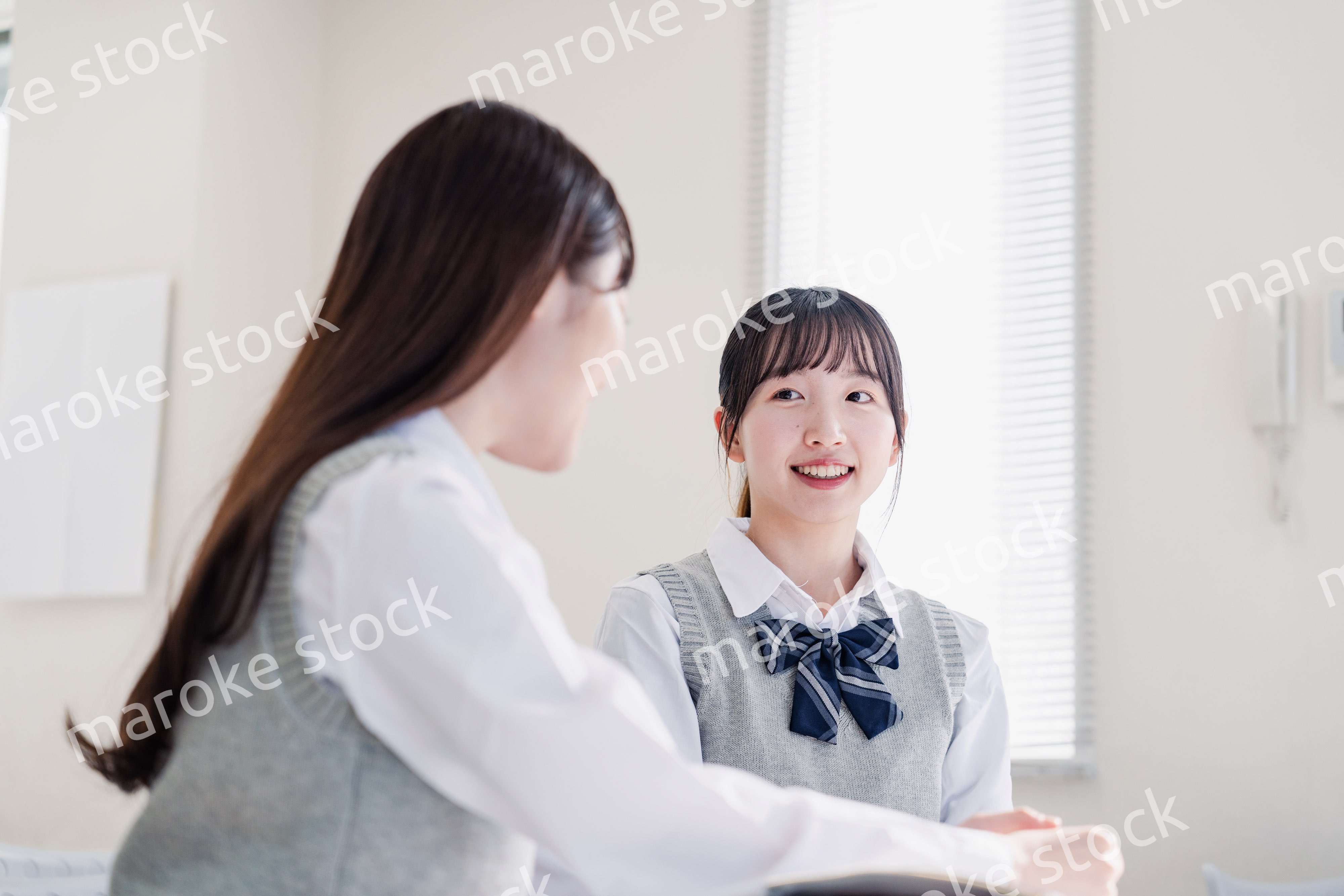 教室で休み時間に話す女子高生