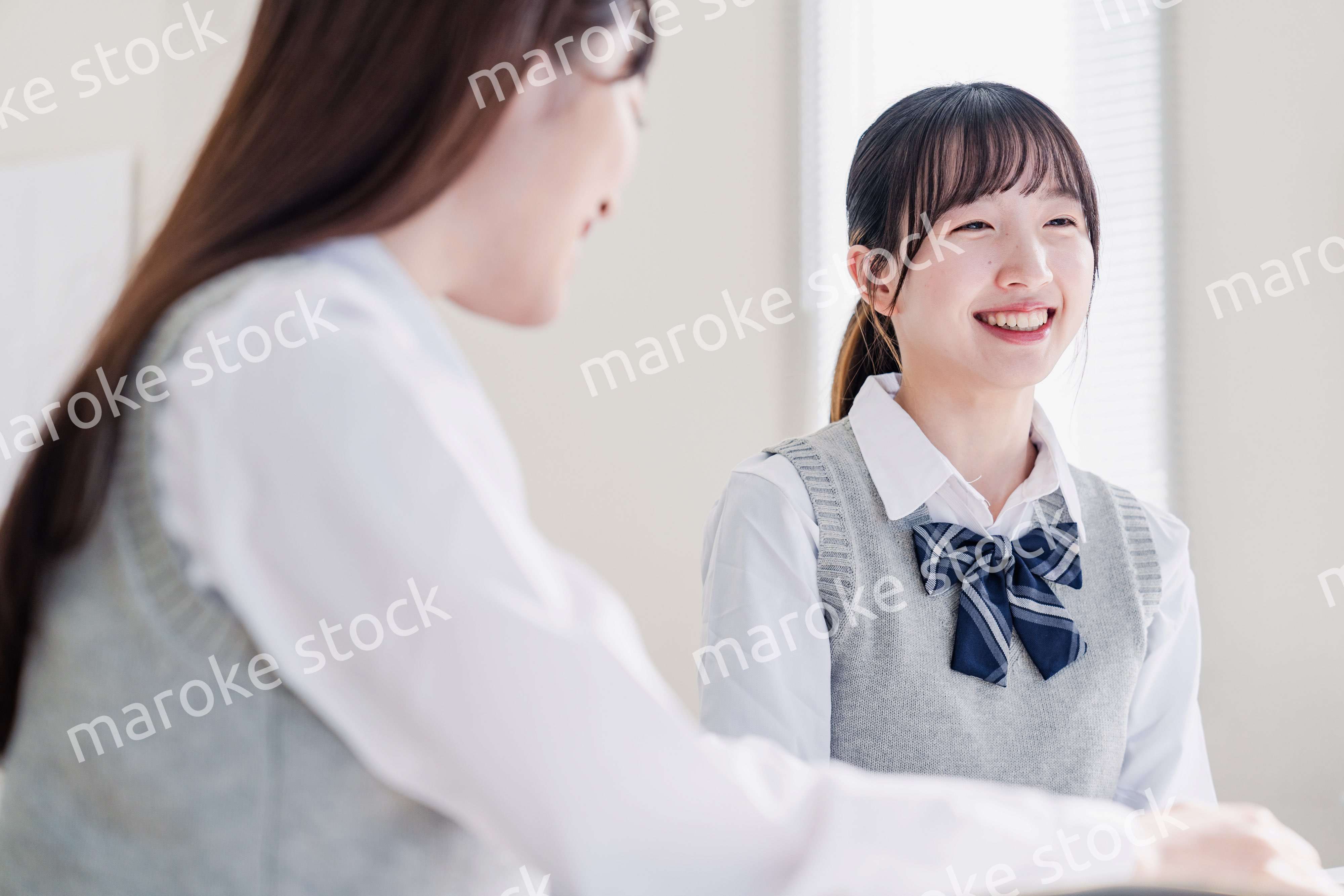 教室で休み時間に話す女子高生