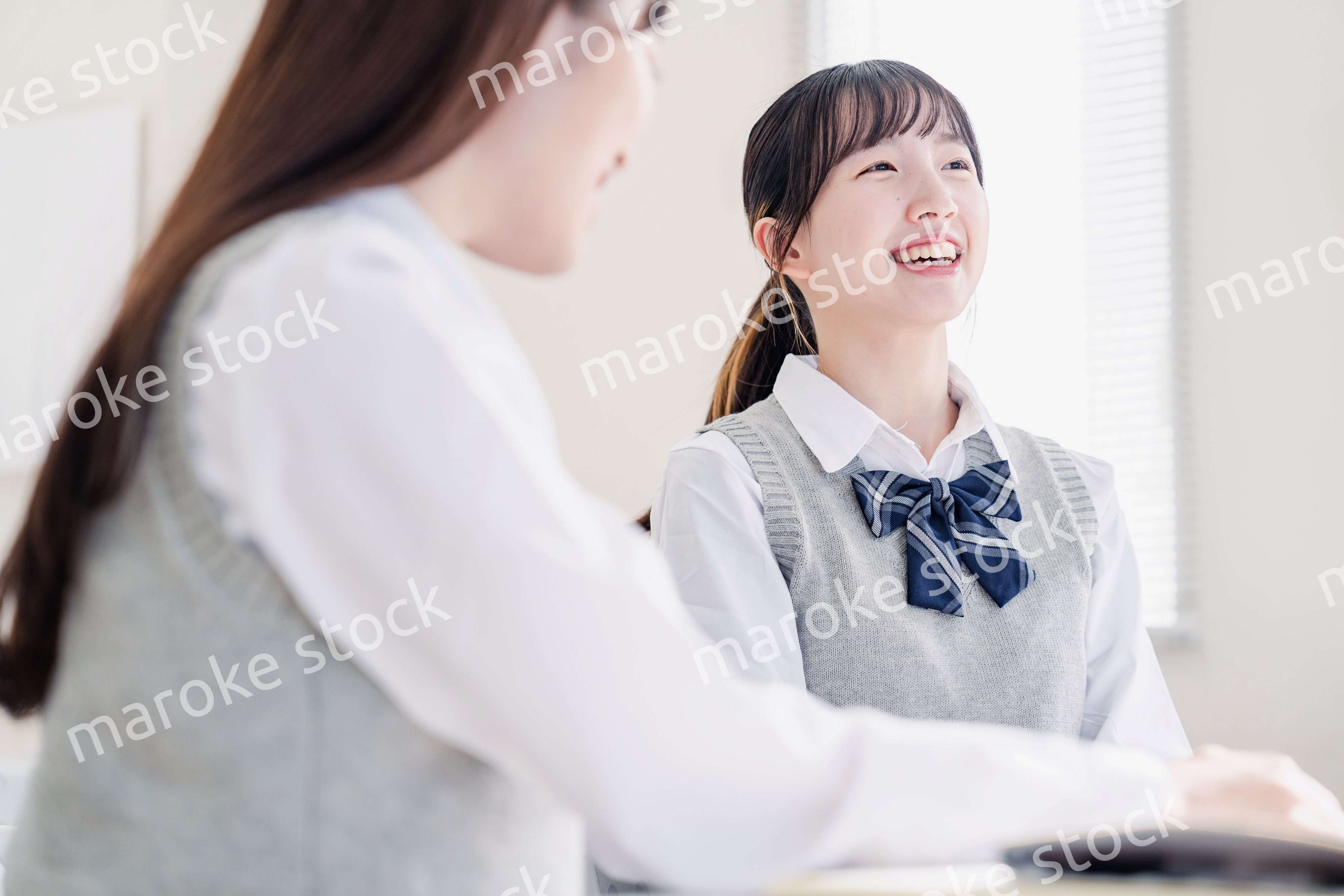 教室で休み時間に話す女子高生