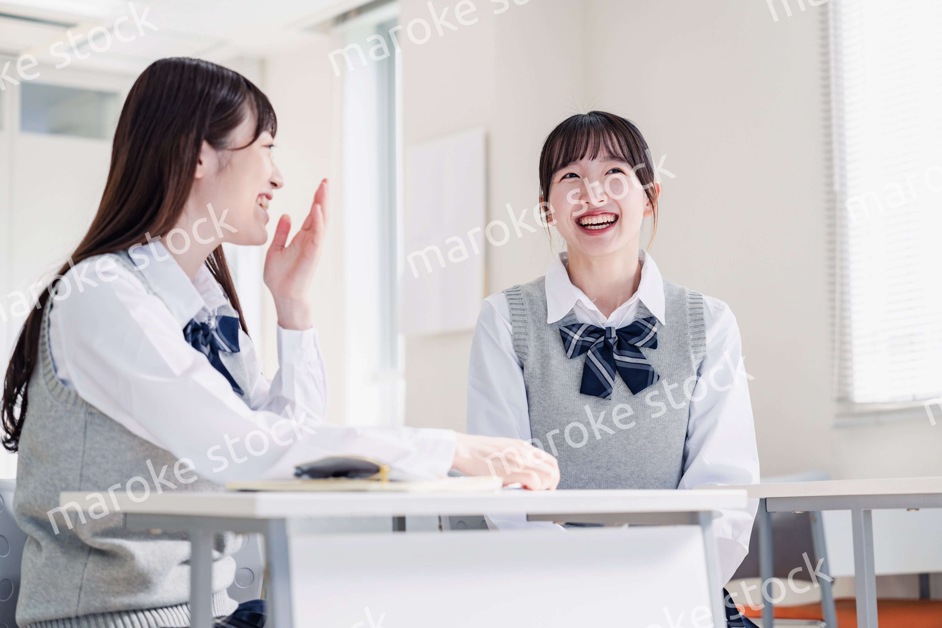 教室で休み時間に話す女子高生