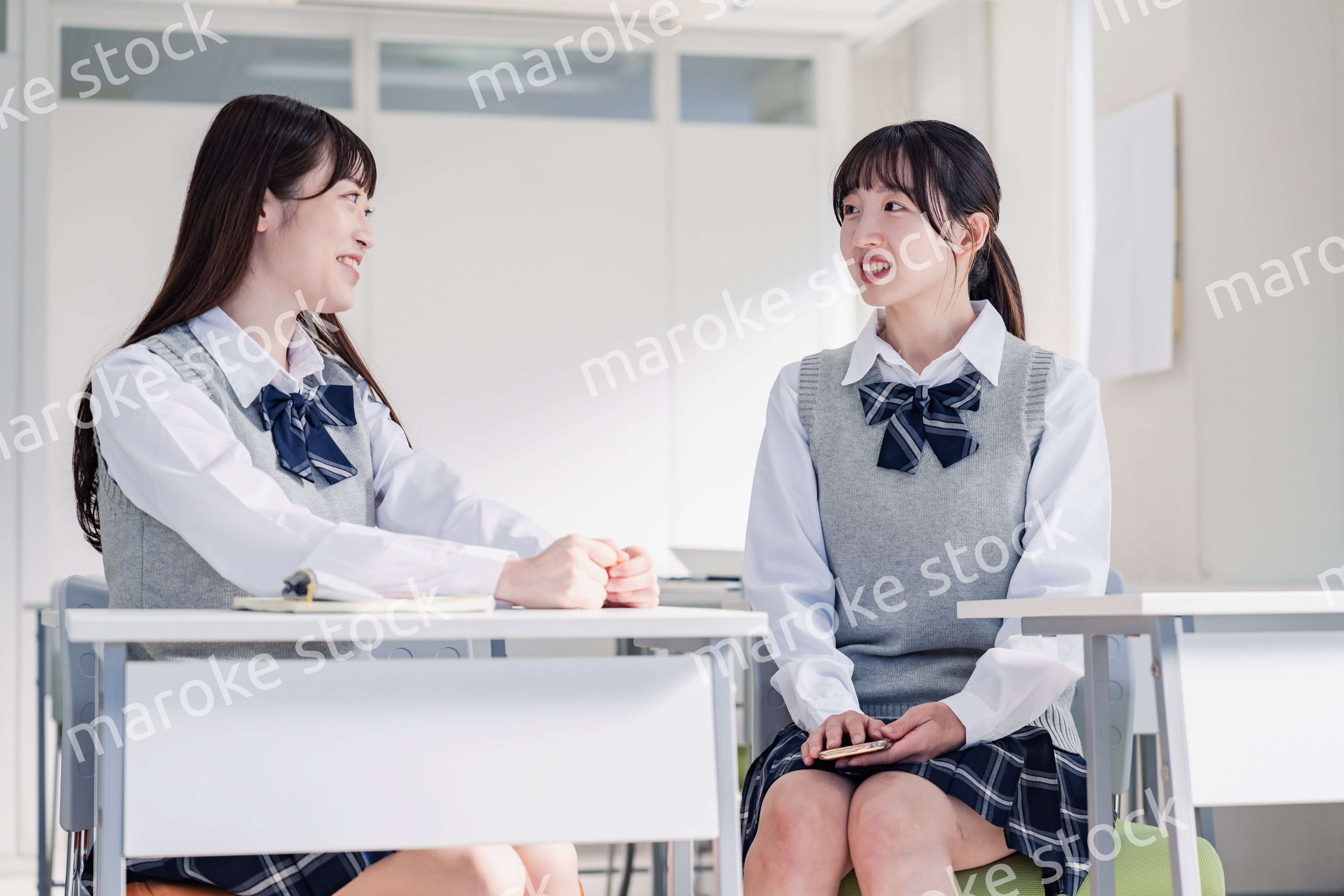 教室で休み時間に話す女子高生