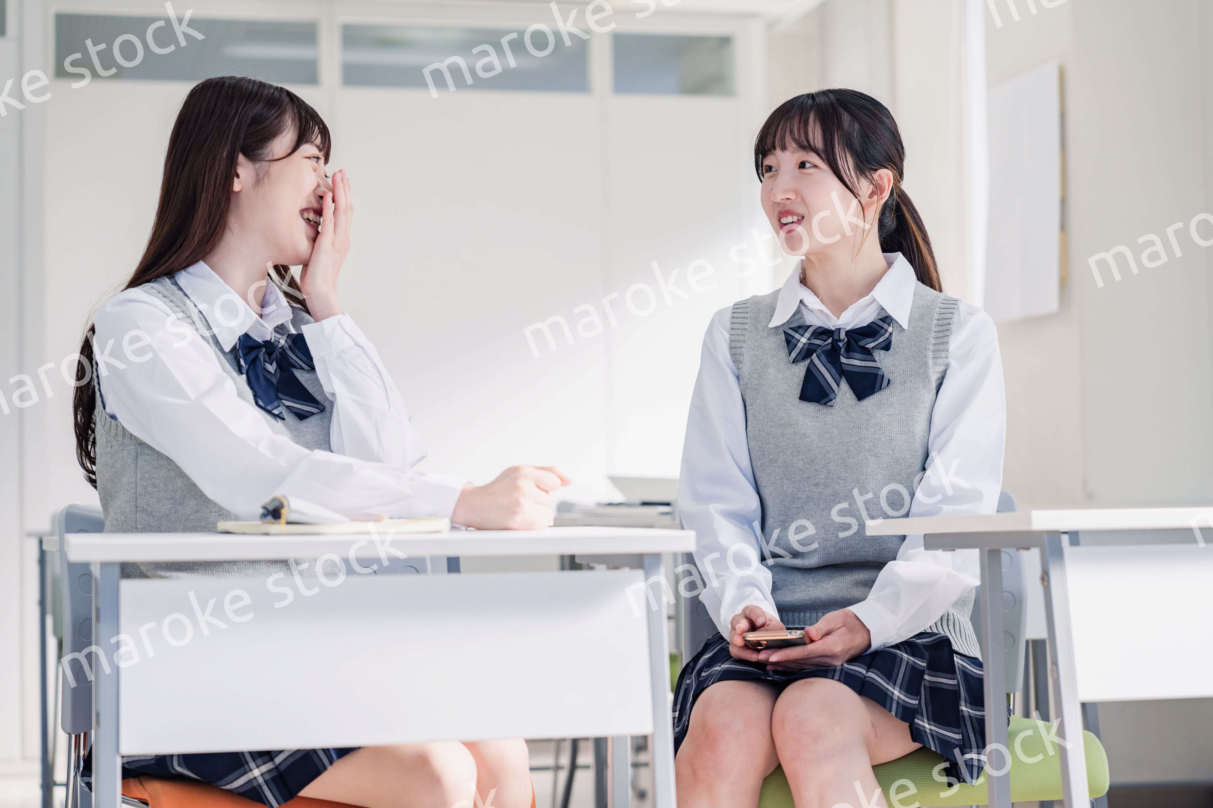 教室で休み時間に話す女子高生