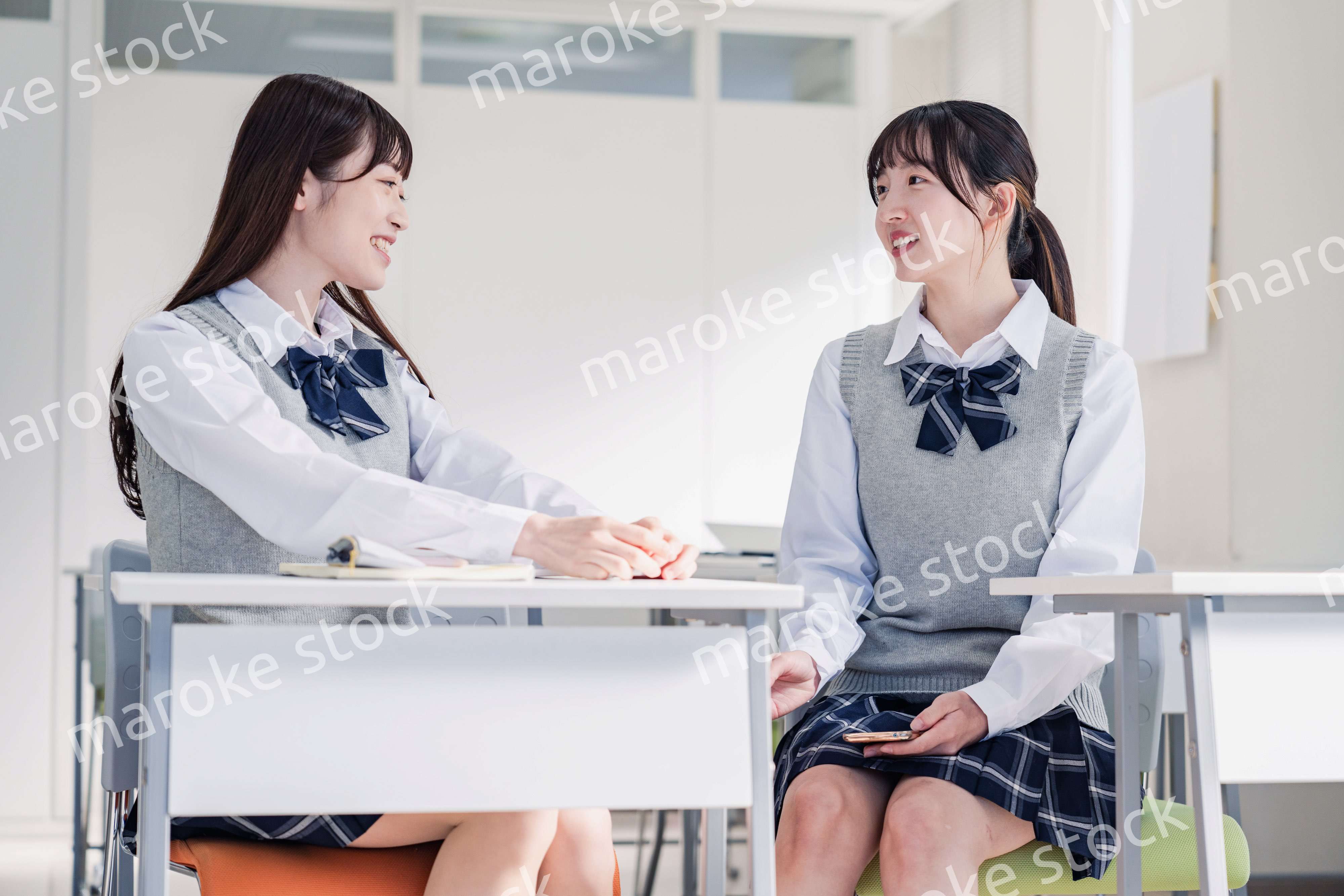 教室で休み時間に話す女子高生