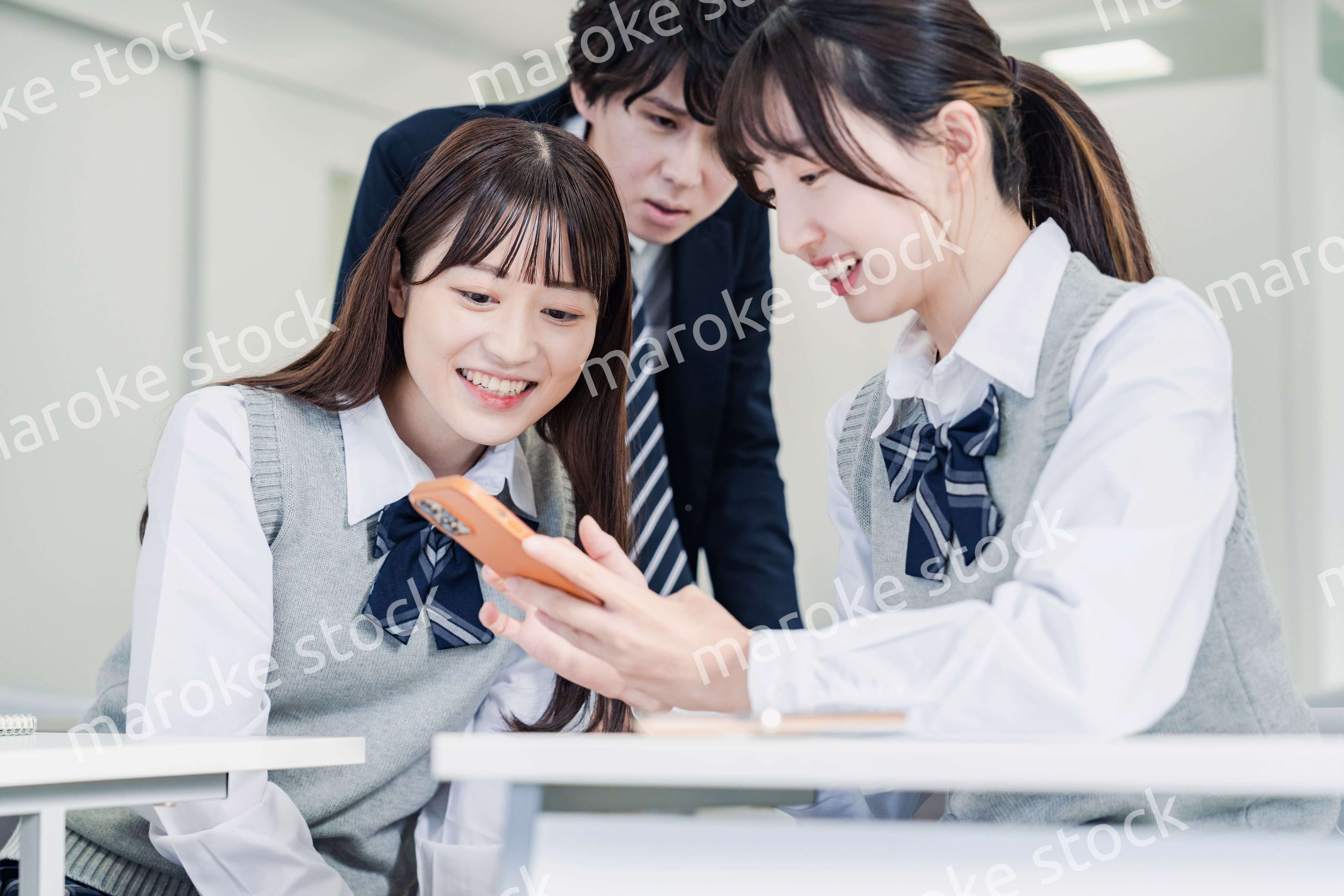 教室でSNSをみんなで見る高校生