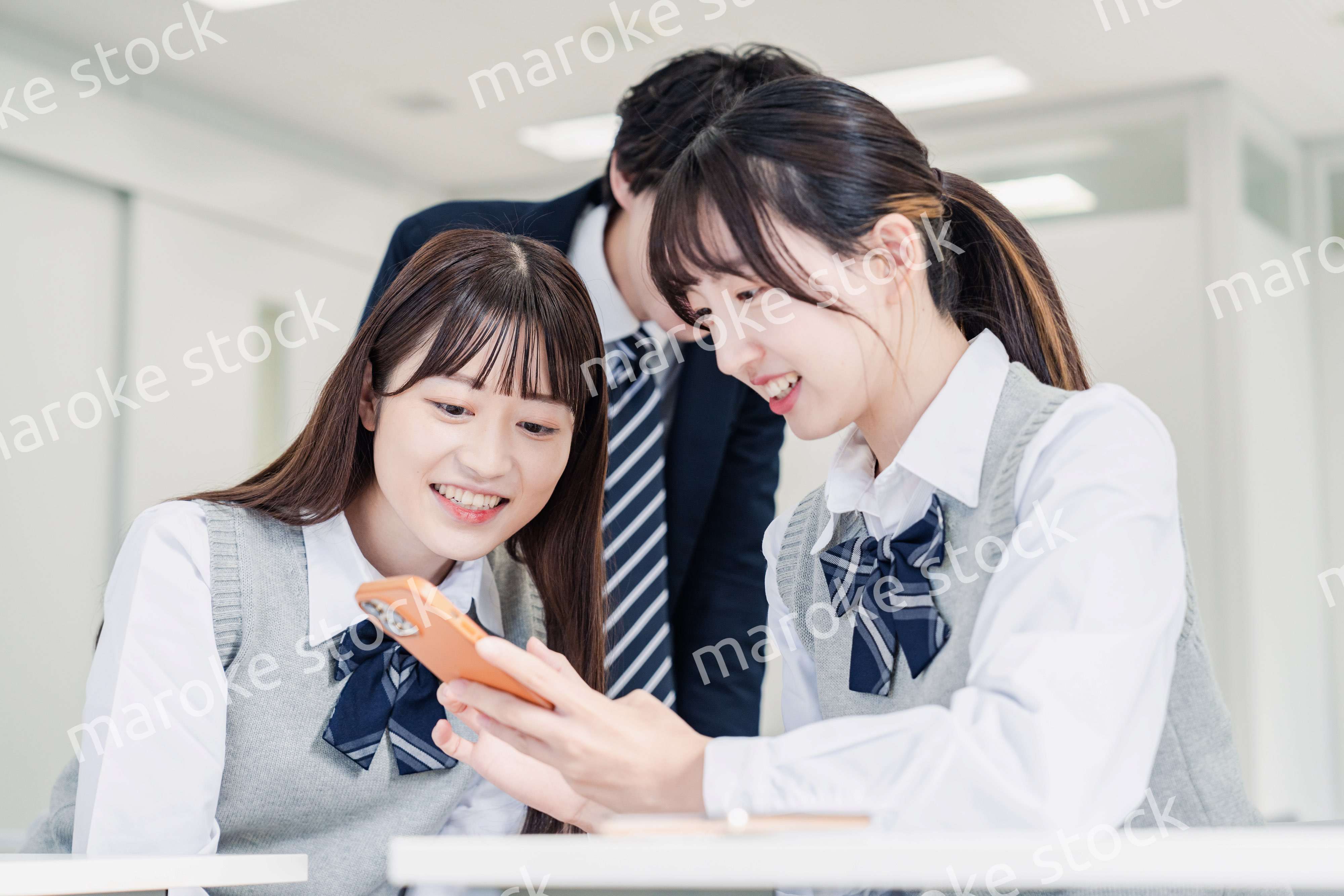 教室でSNSをみんなで見る高校生