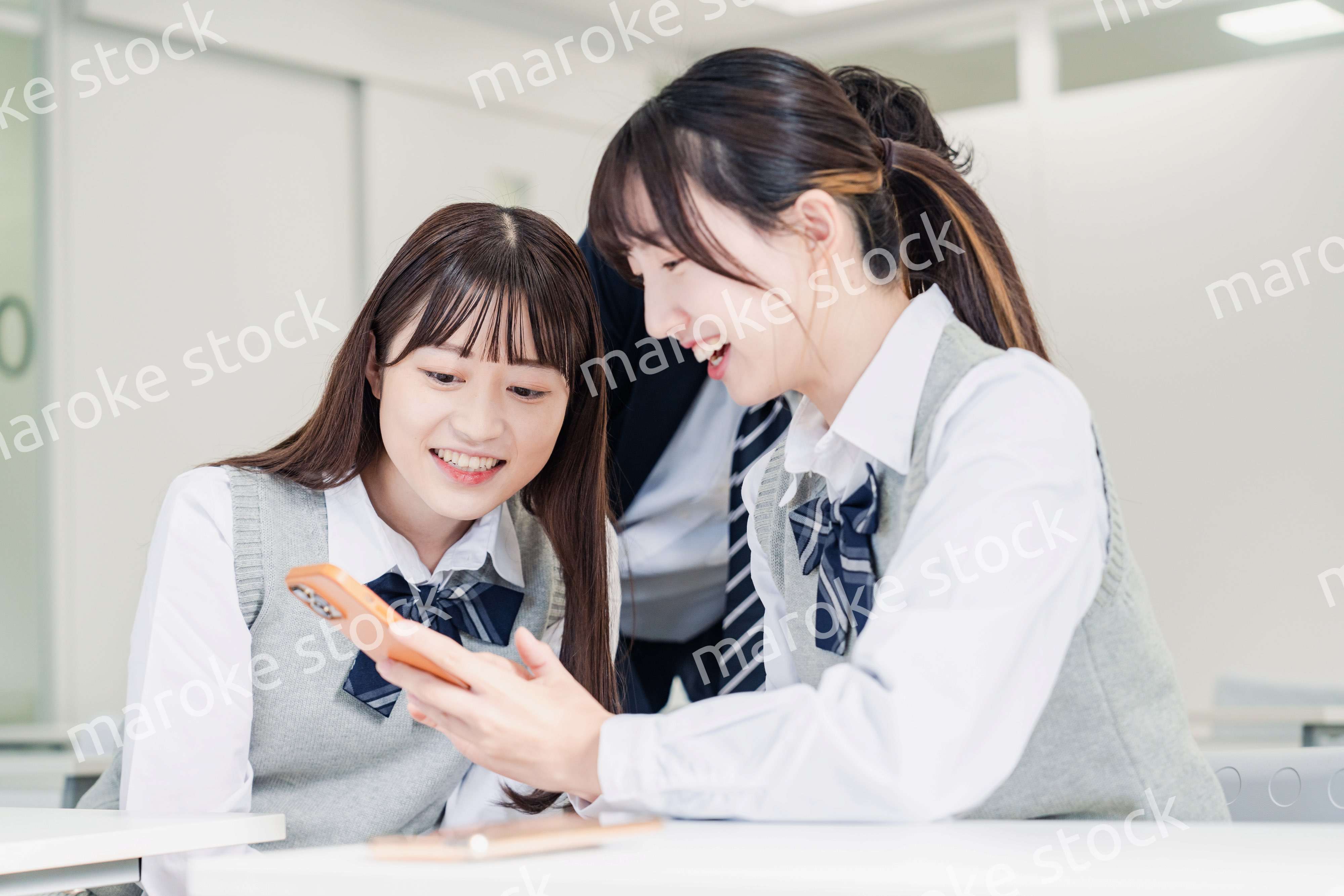 教室でSNSをみんなで見る高校生