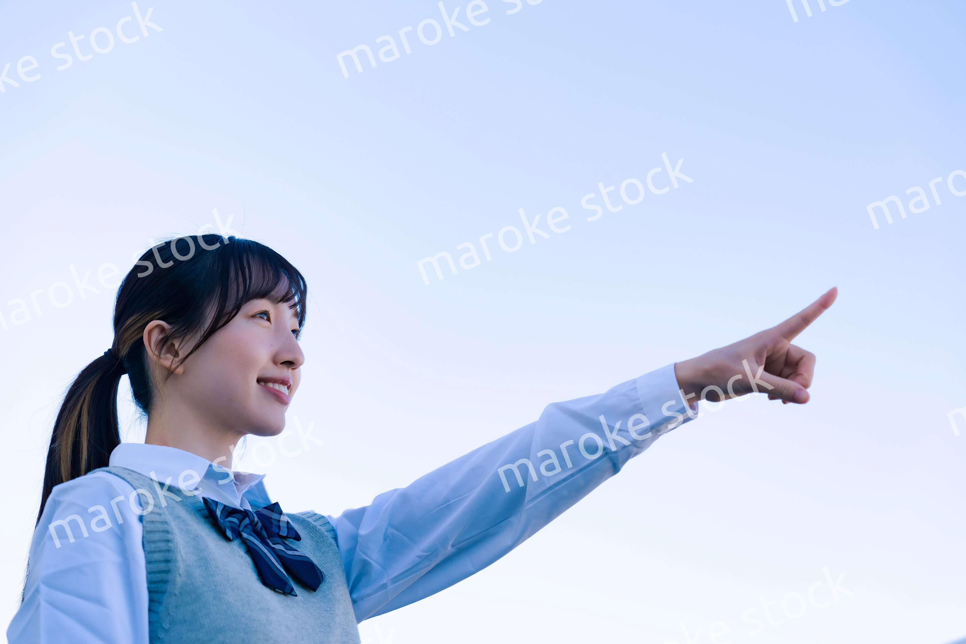 制服で上を指差す女子高生