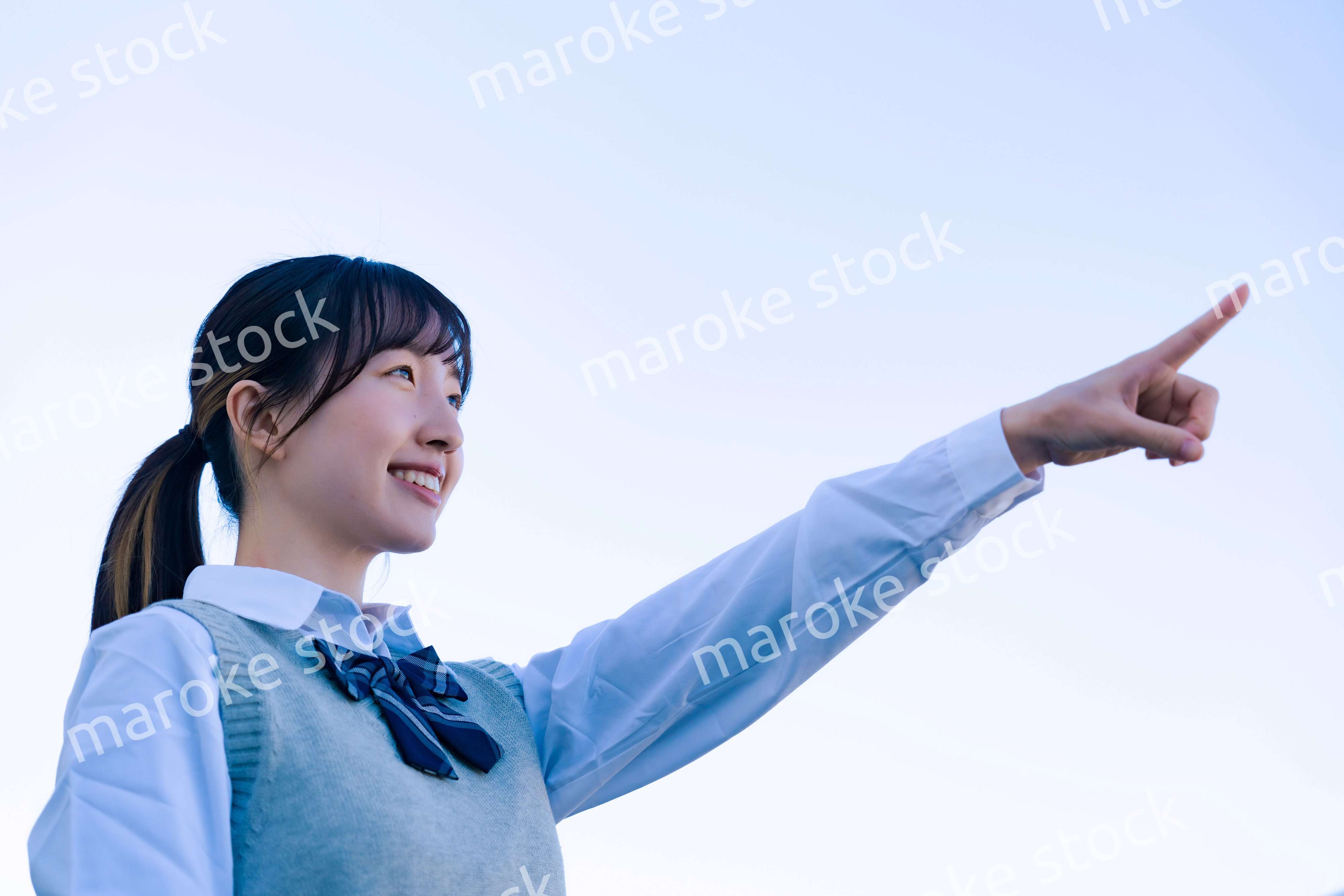 制服で上を指差す女子高生