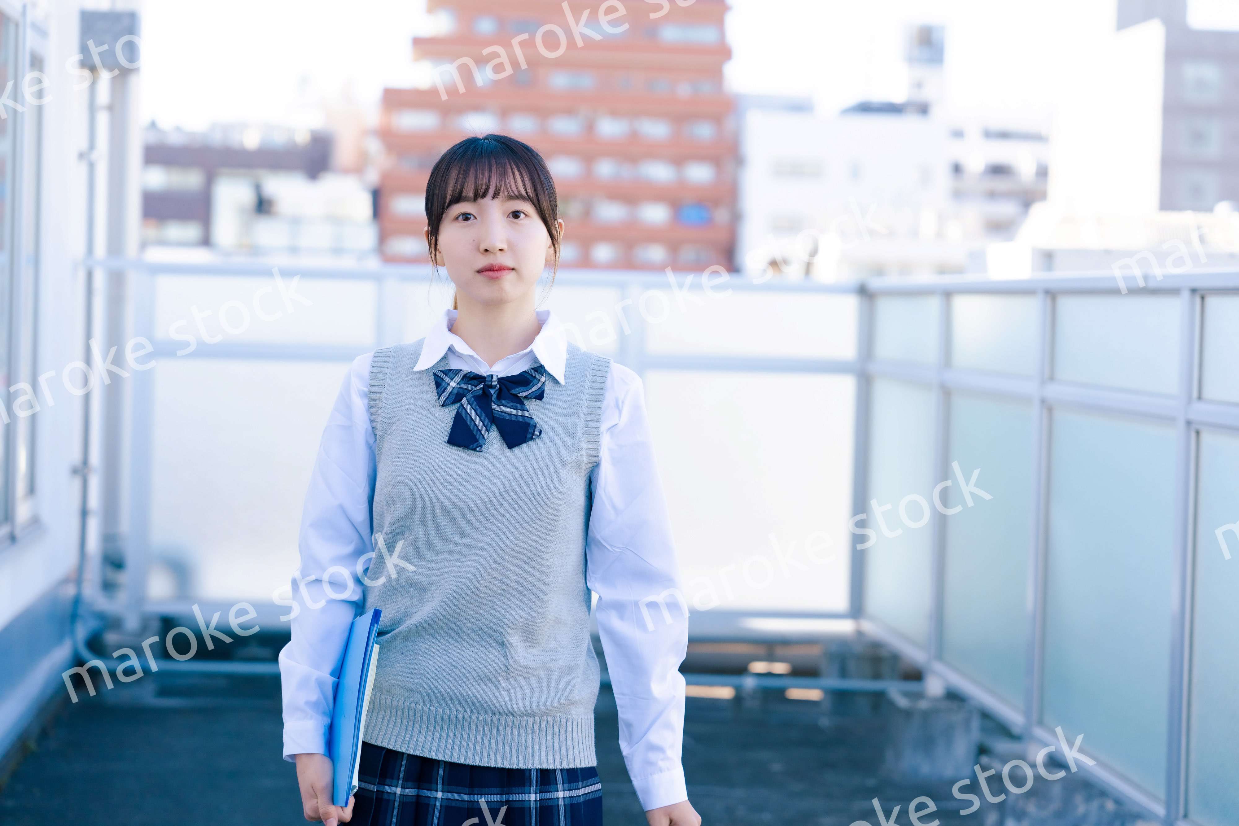 学校の屋上を歩く女子高生