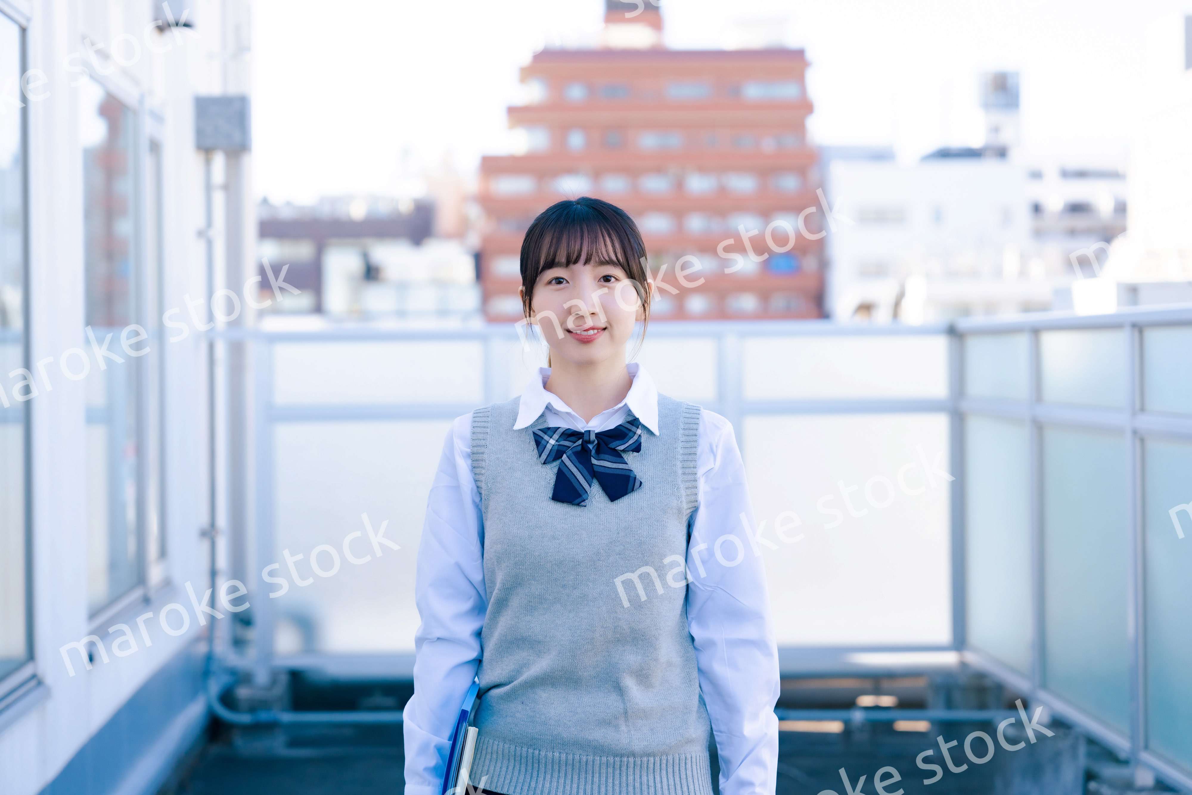 学校の屋上を歩く女子高生