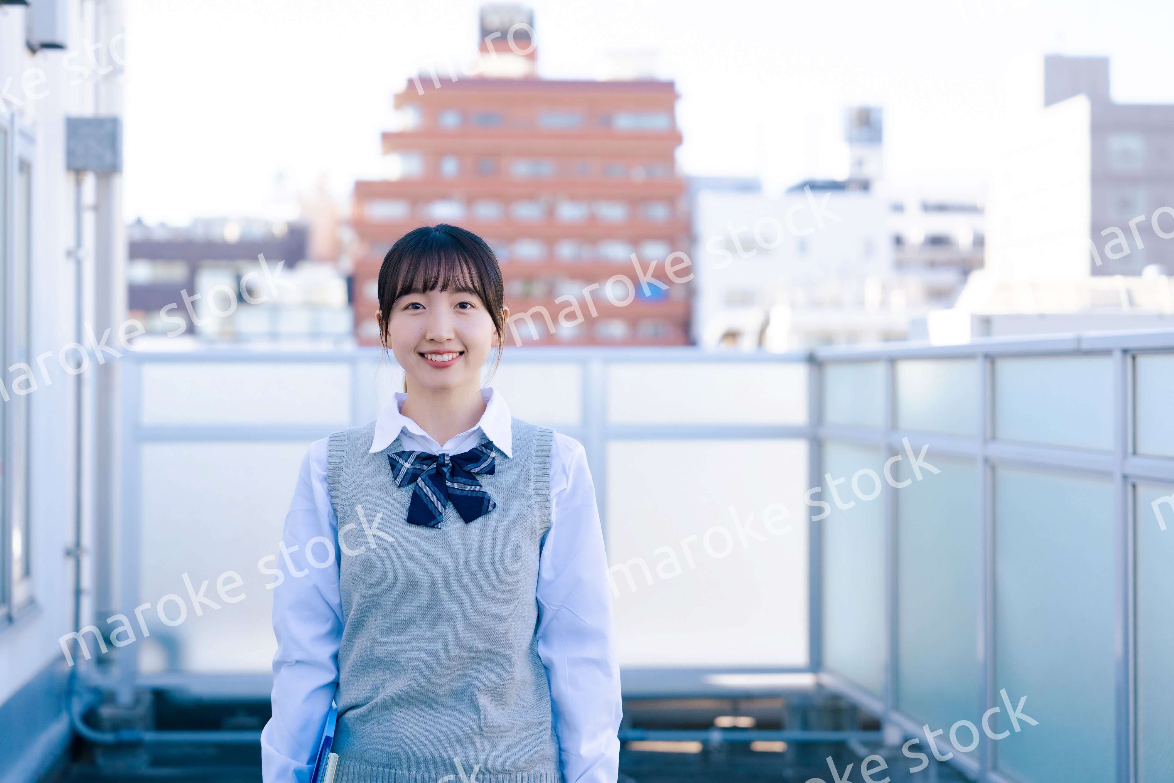 学校の屋上を歩く女子高生