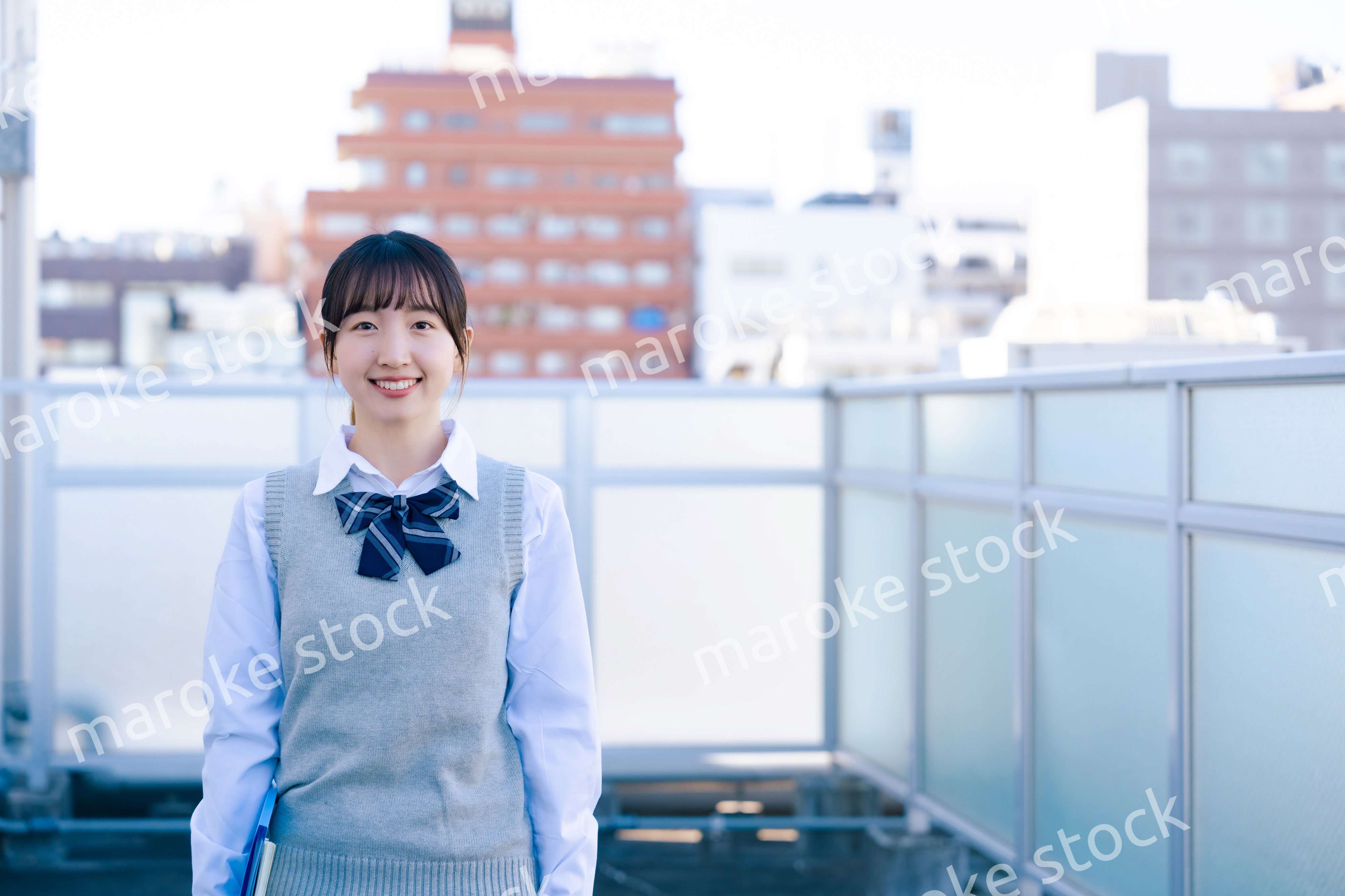 学校の屋上を歩く女子高生