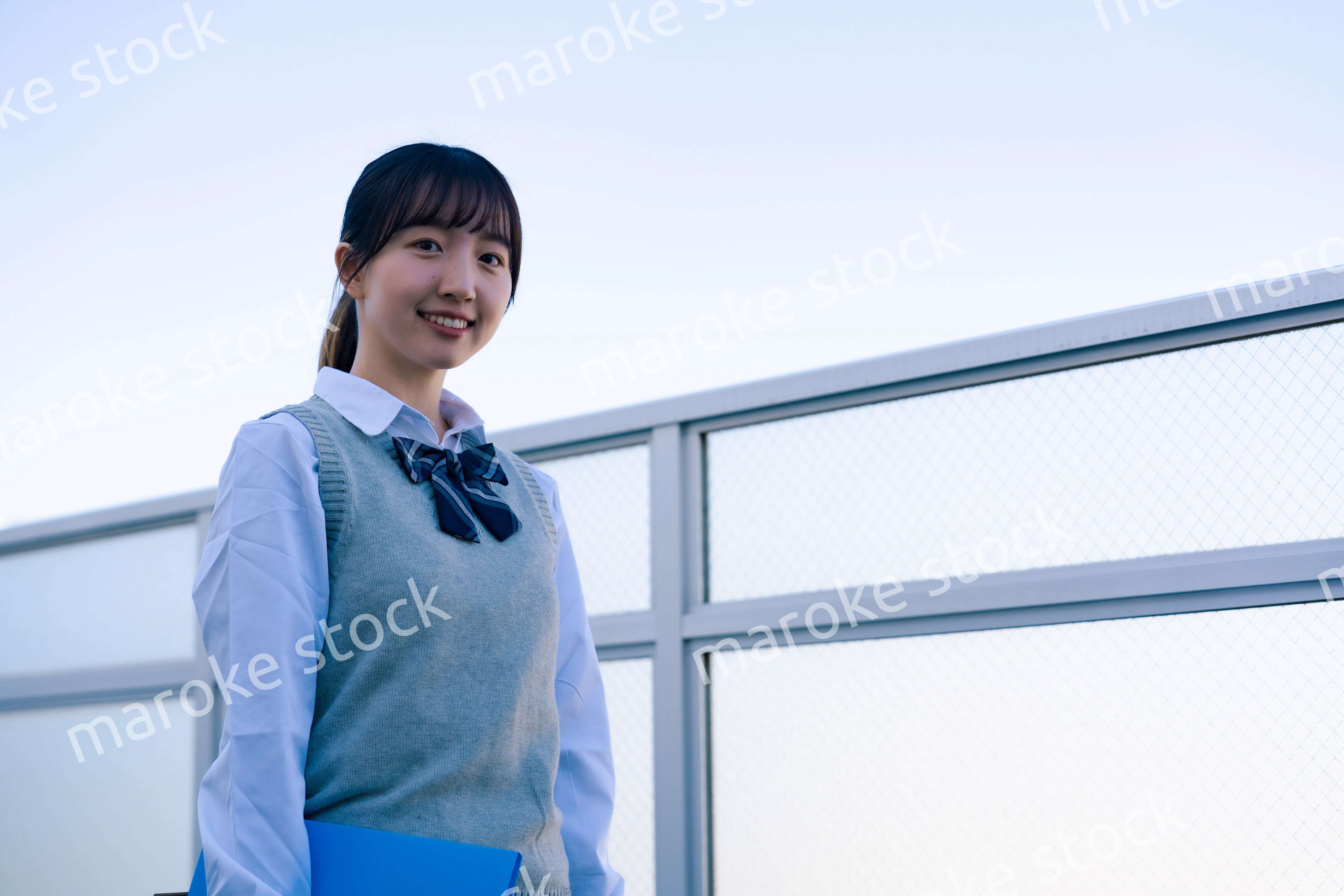 学校の屋上を歩く女子高生