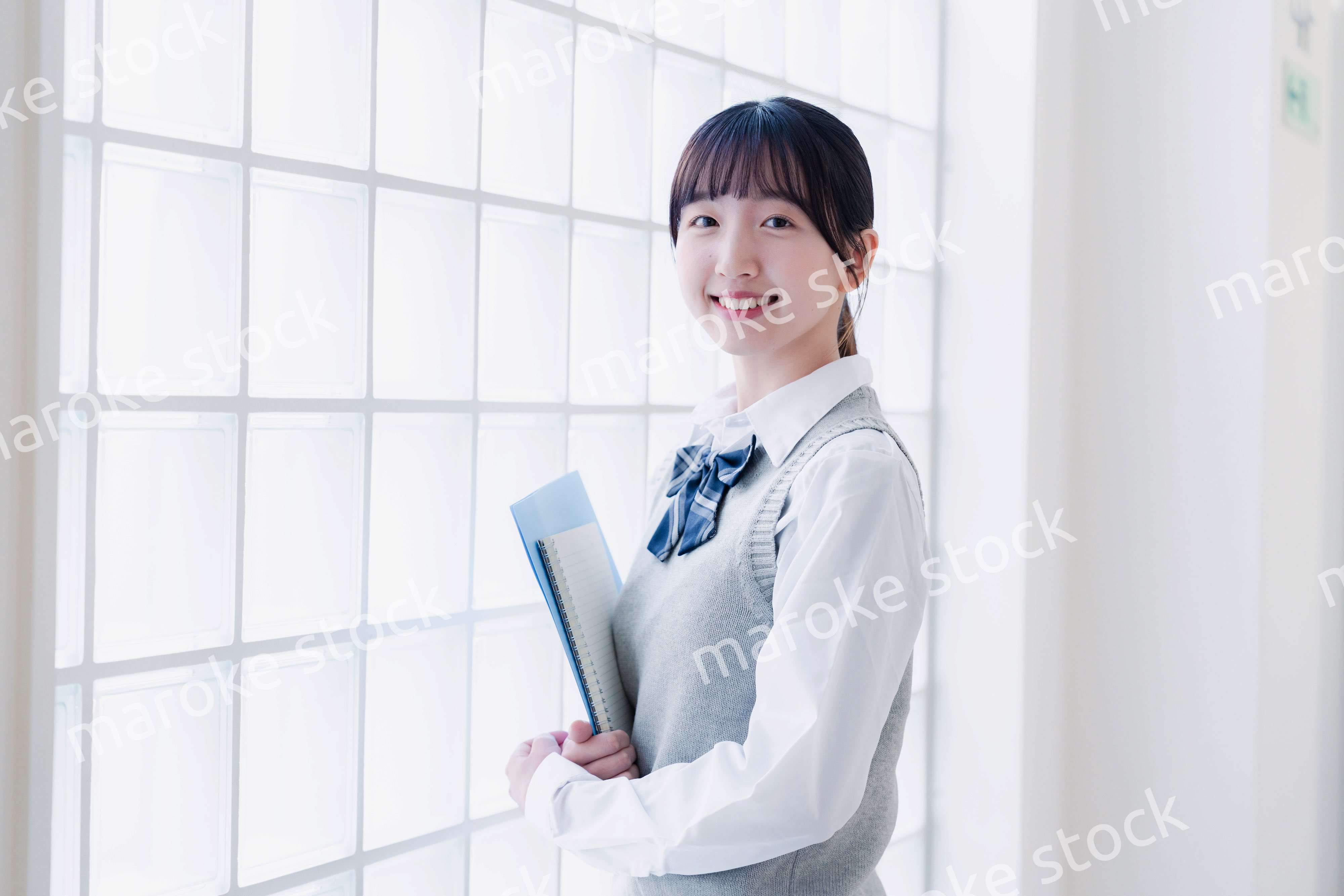 教材を持って校内を歩く女子高生