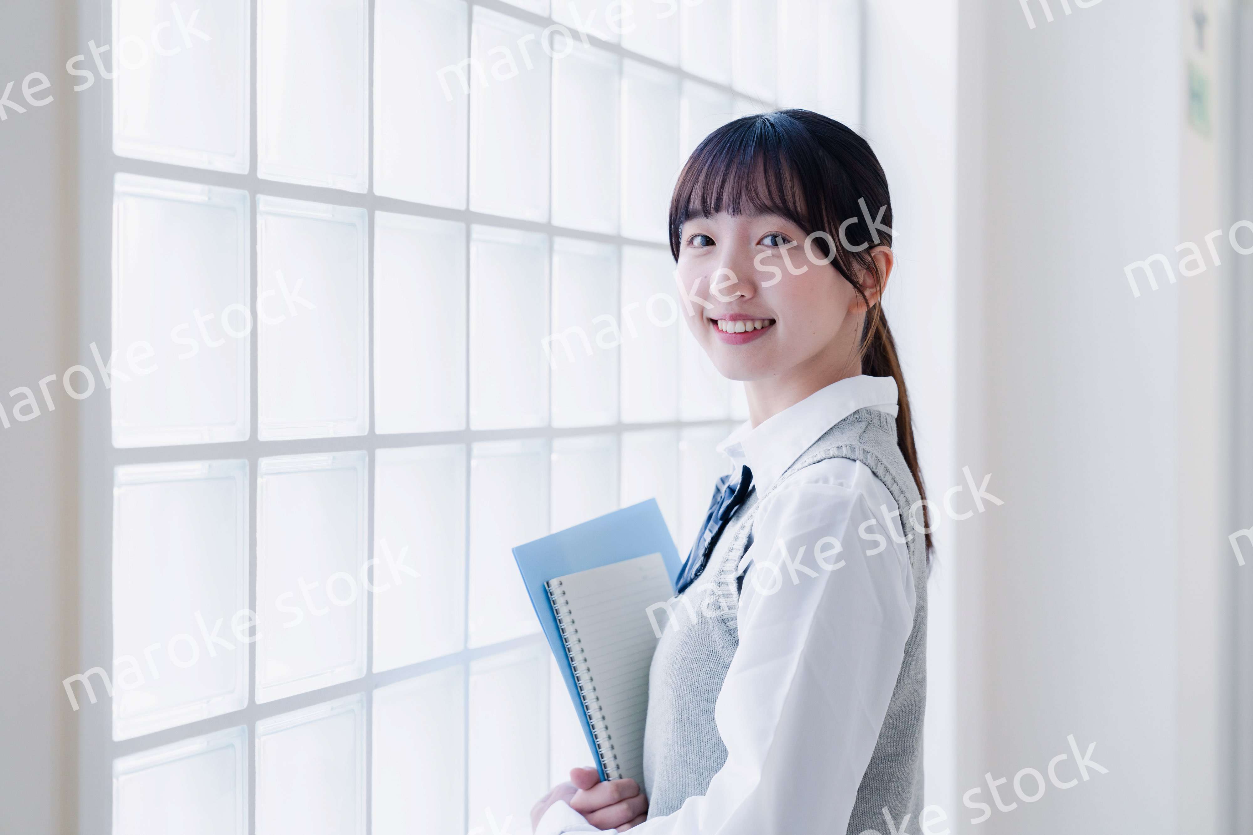 教材を持って校内を歩く女子高生