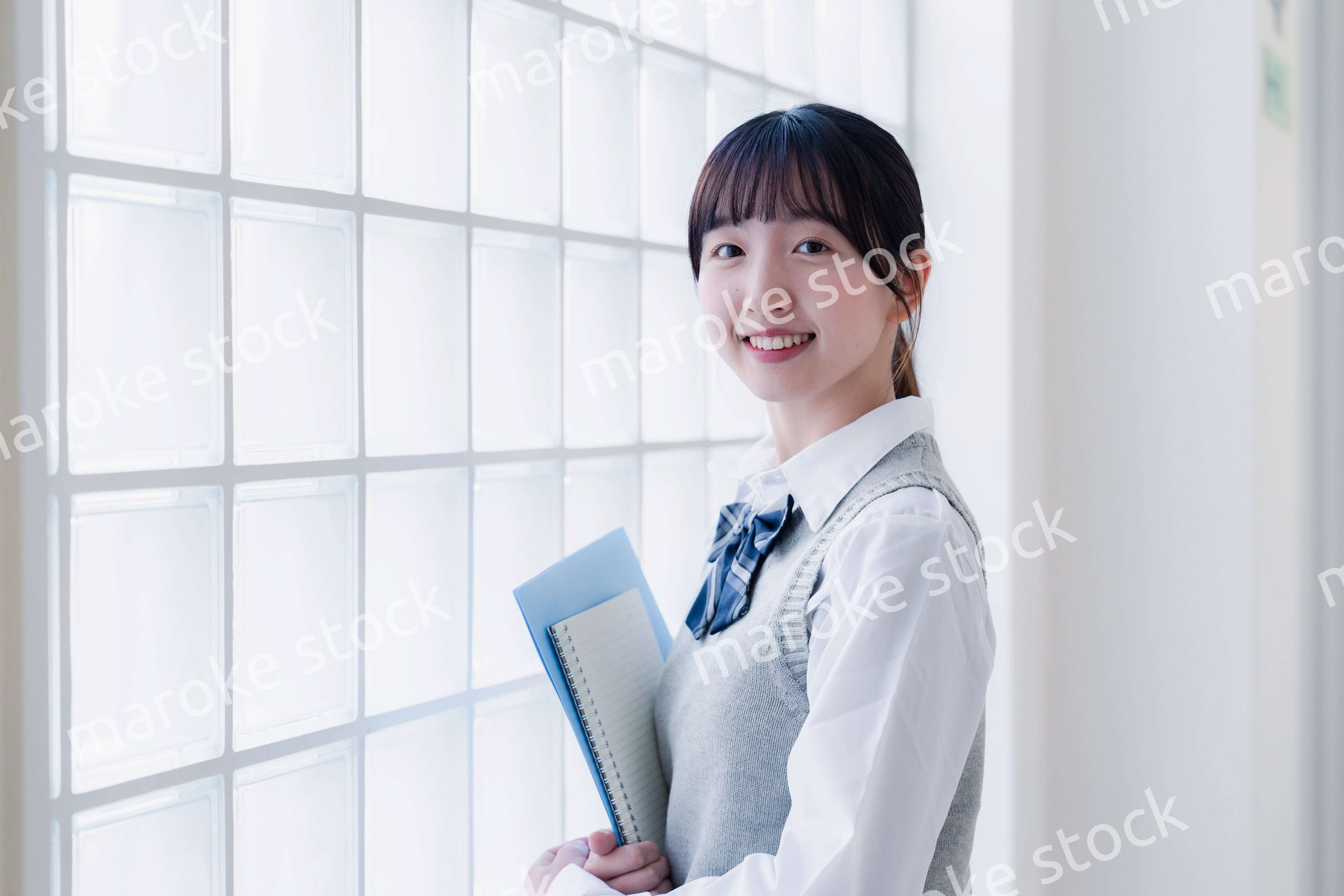 教材を持って校内を歩く女子高生