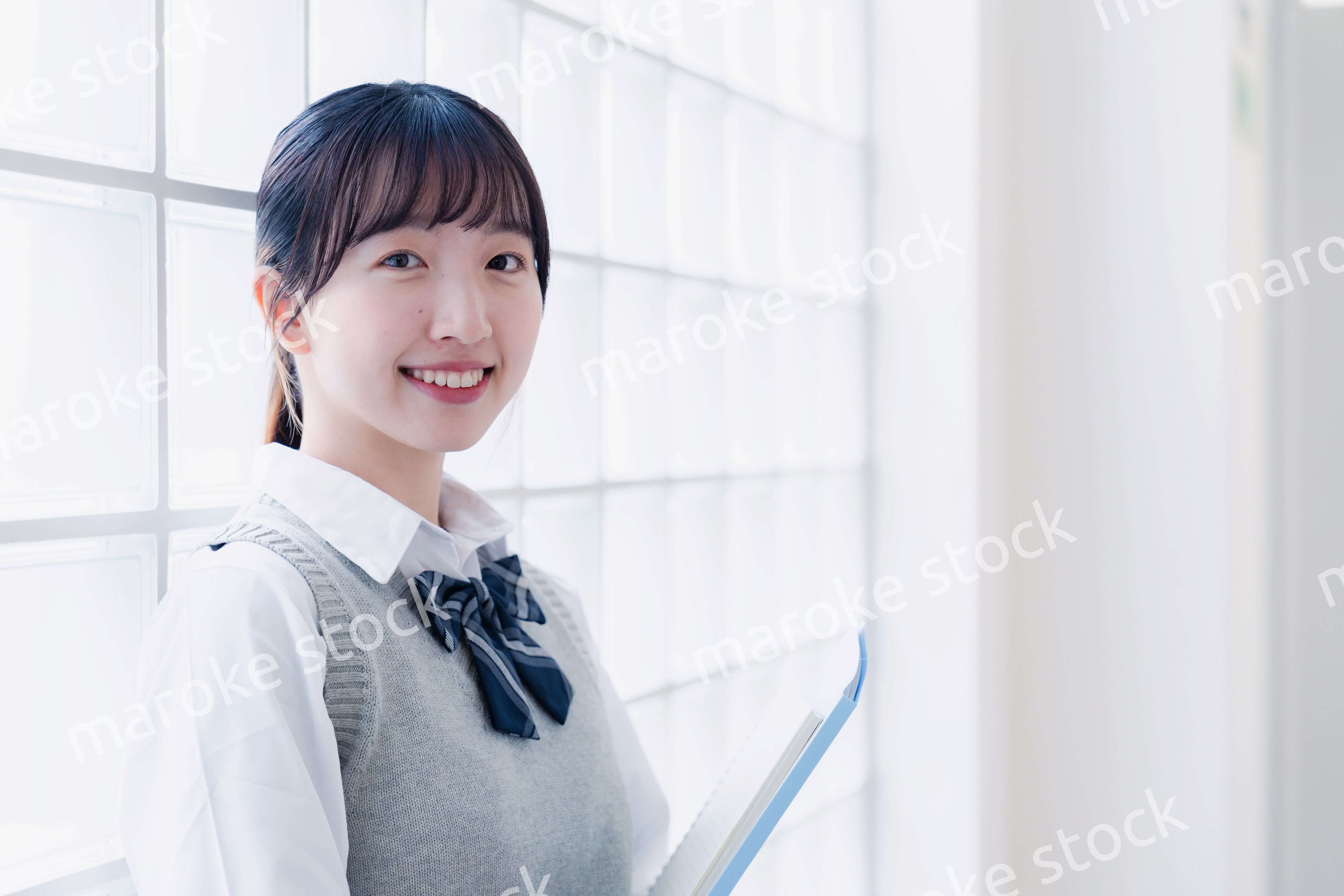 教材を持って校内を歩く女子高生