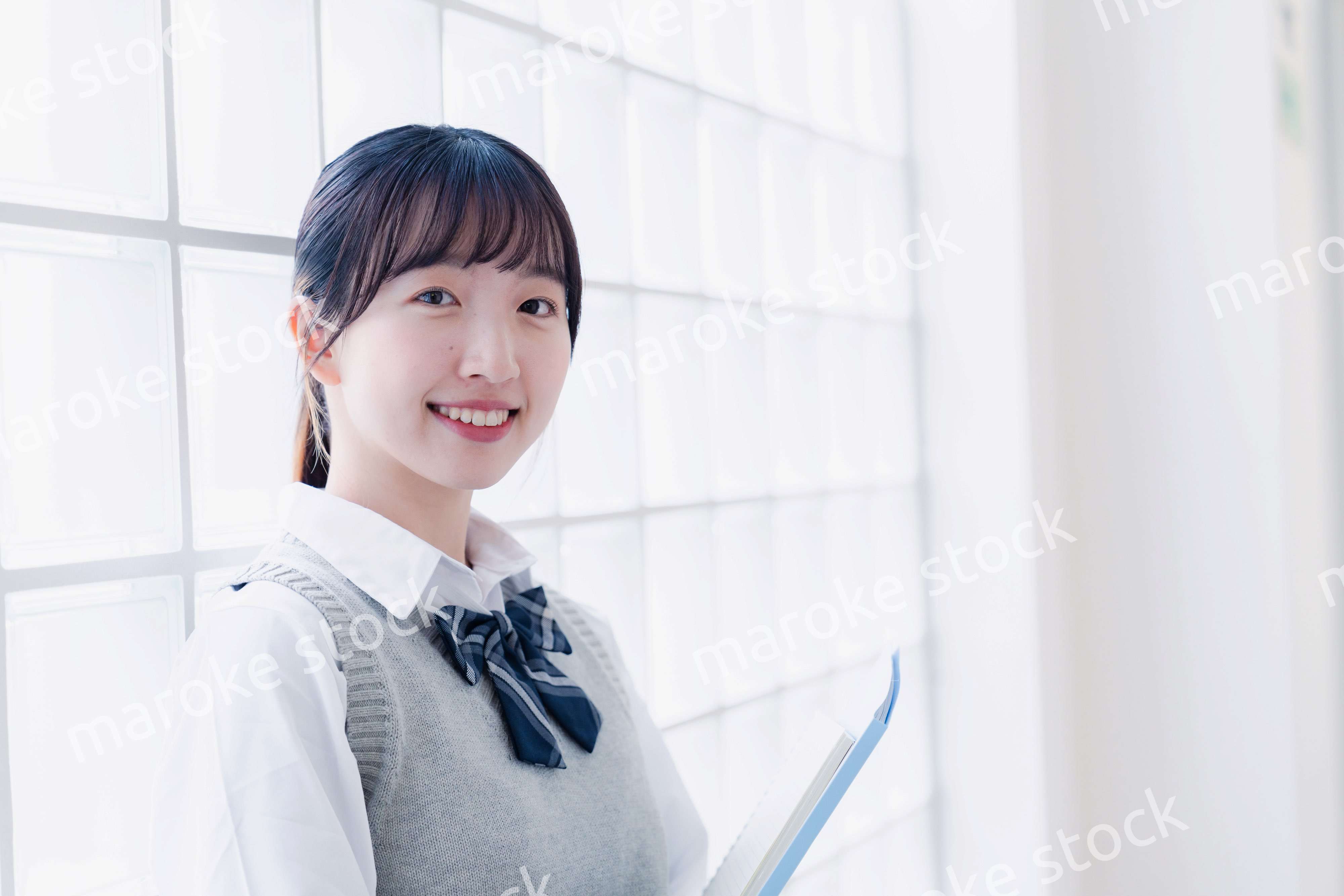 教材を持って校内を歩く女子高生