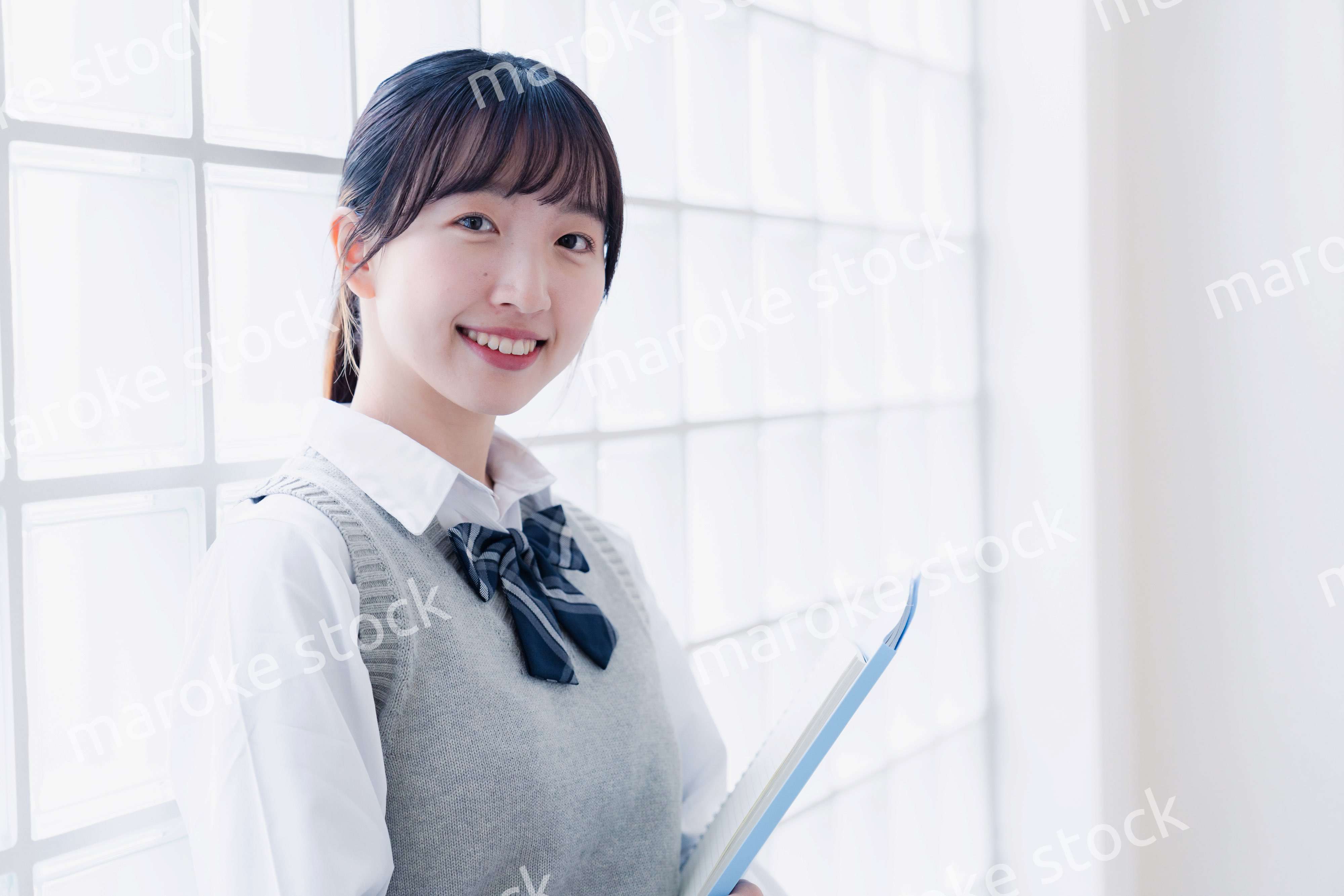 教材を持って校内を歩く女子高生