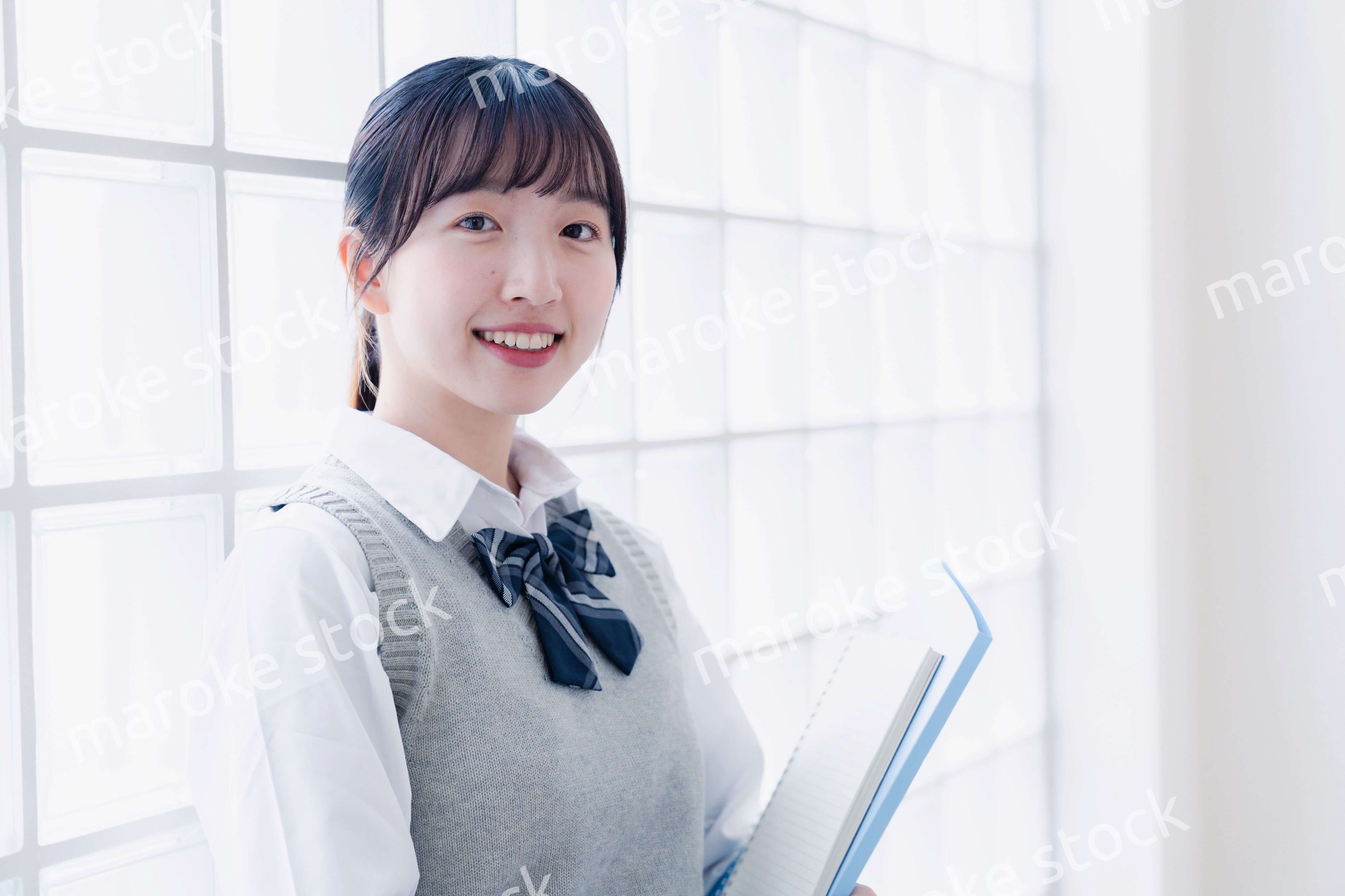 教材を持って校内を歩く女子高生