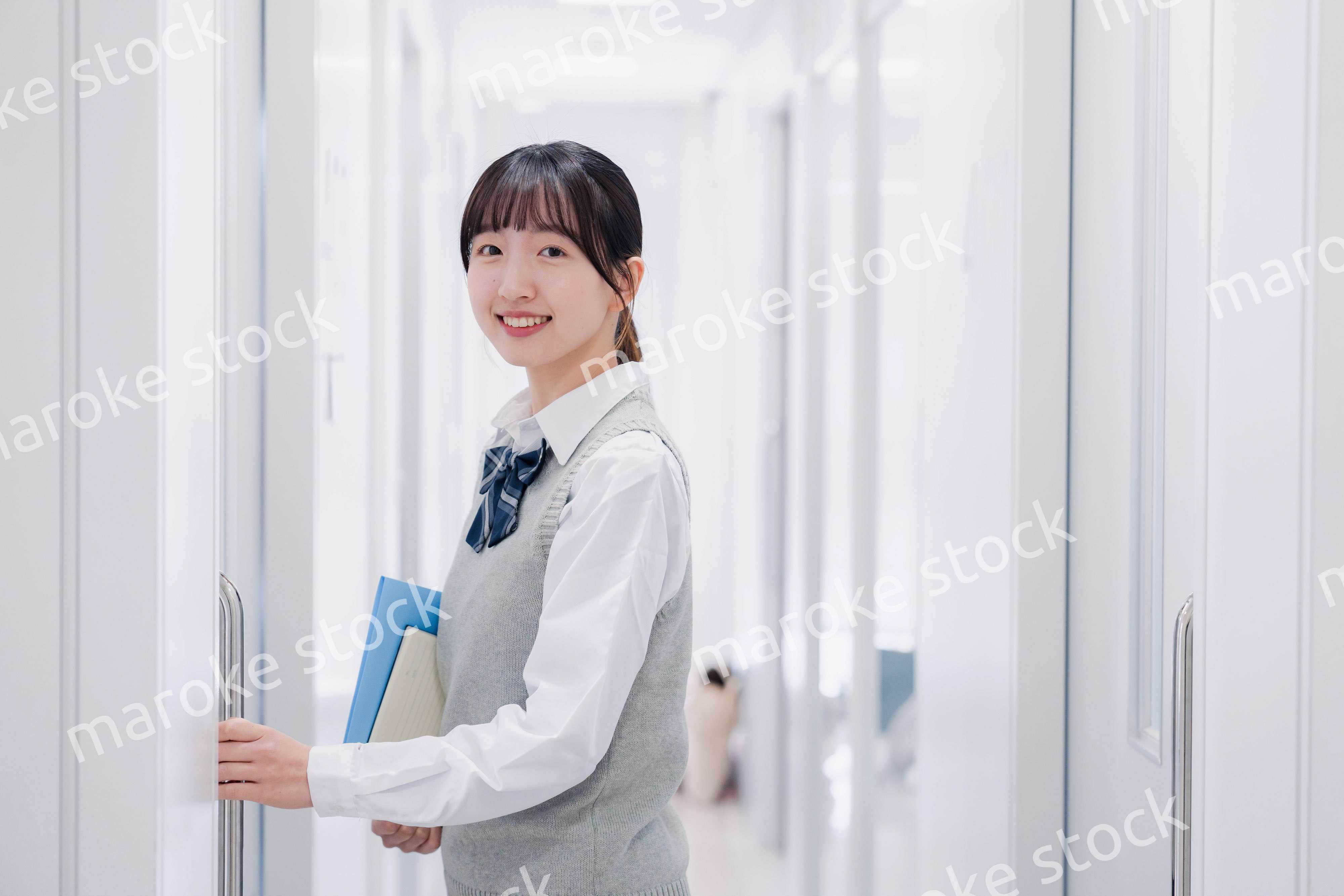 教材を持って校内を歩く女子高生