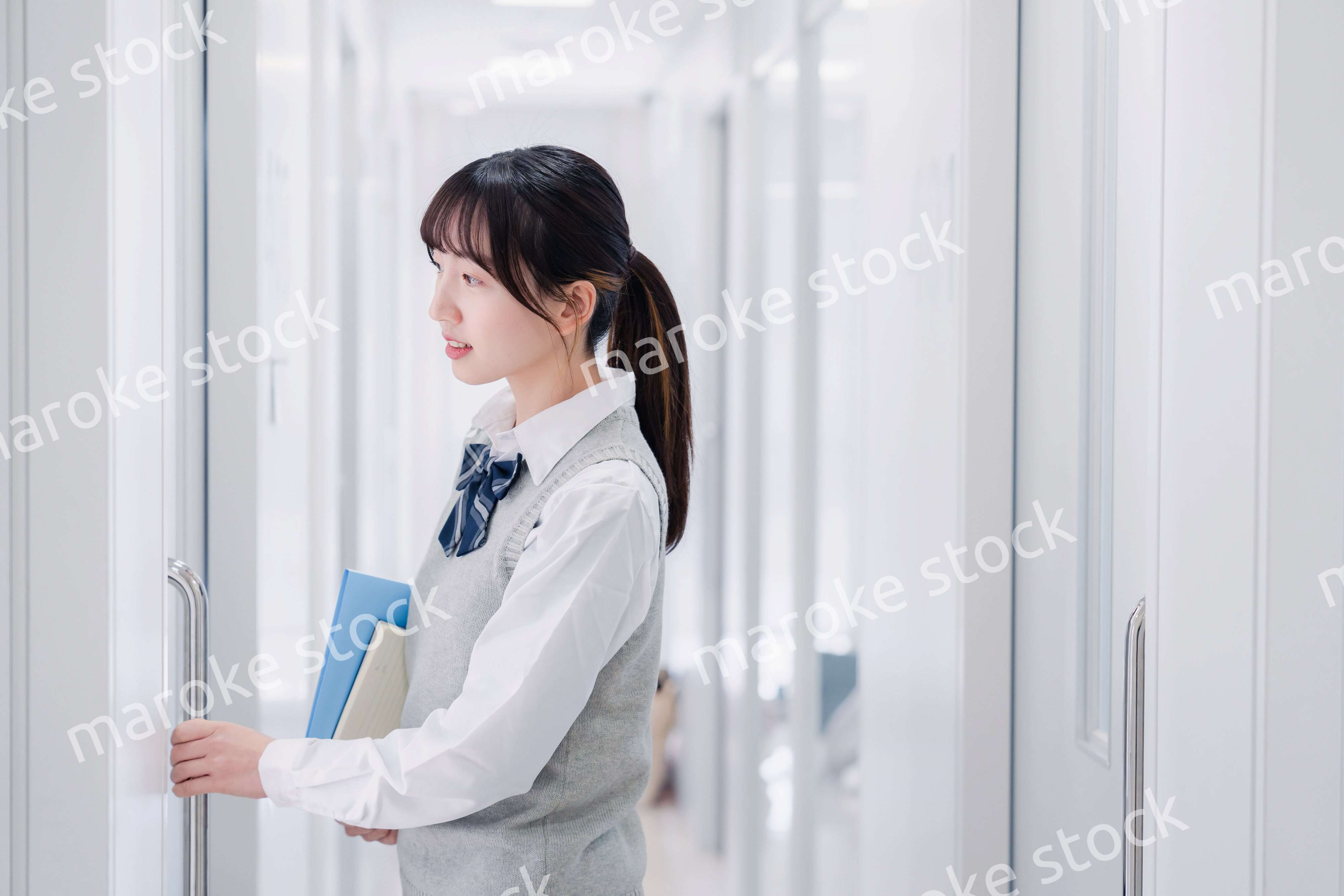 教材を持って校内を歩く女子高生